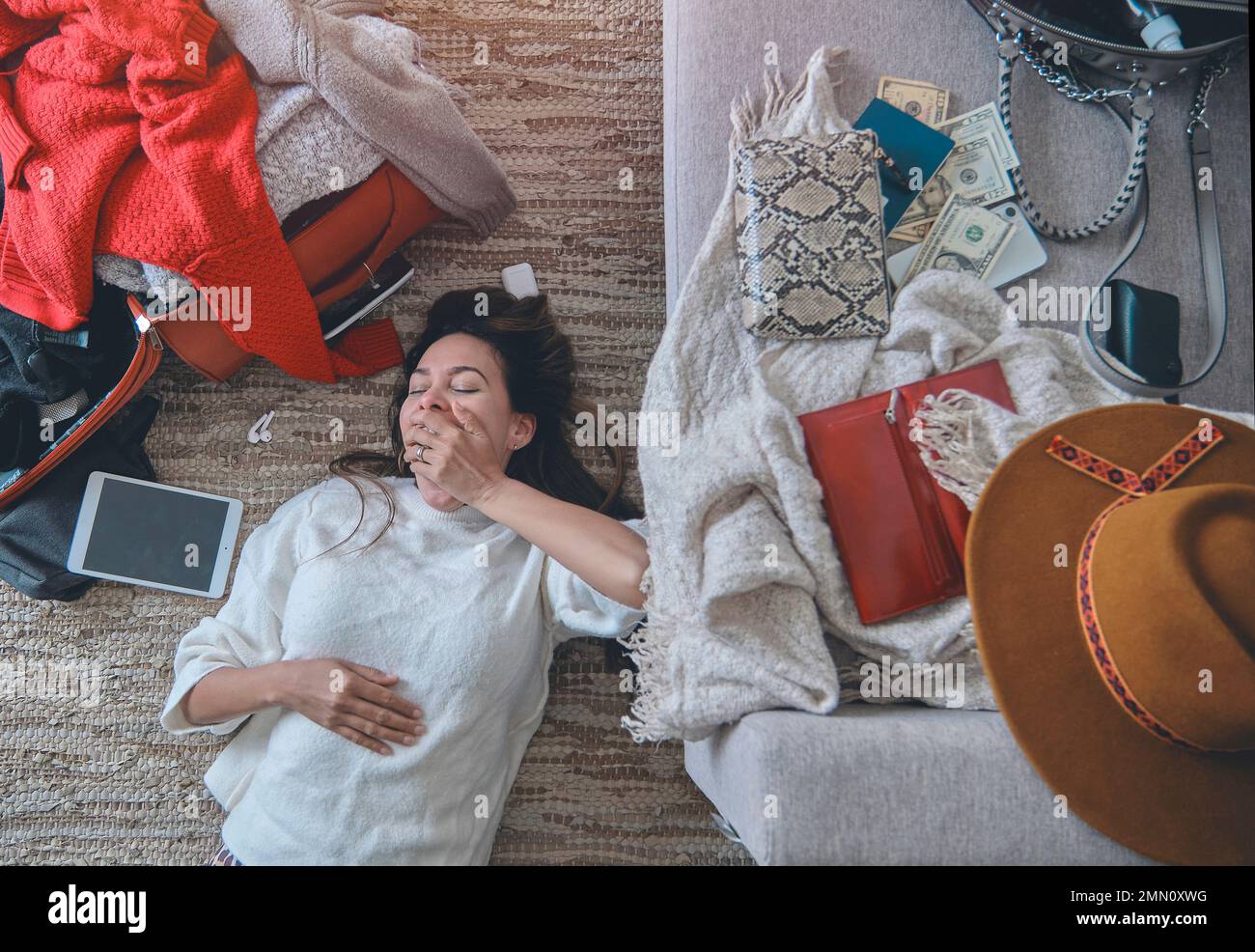 Young woman just arrived in the hotel and relaxing at the floor after a ...