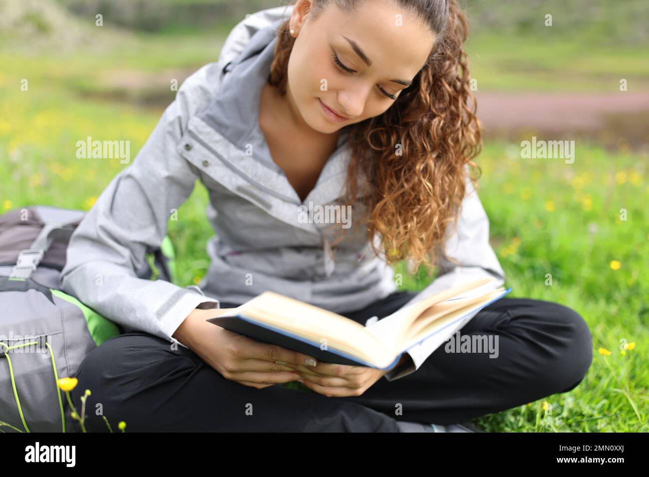 Hiker reading a paper book in the mountain Stock Photo