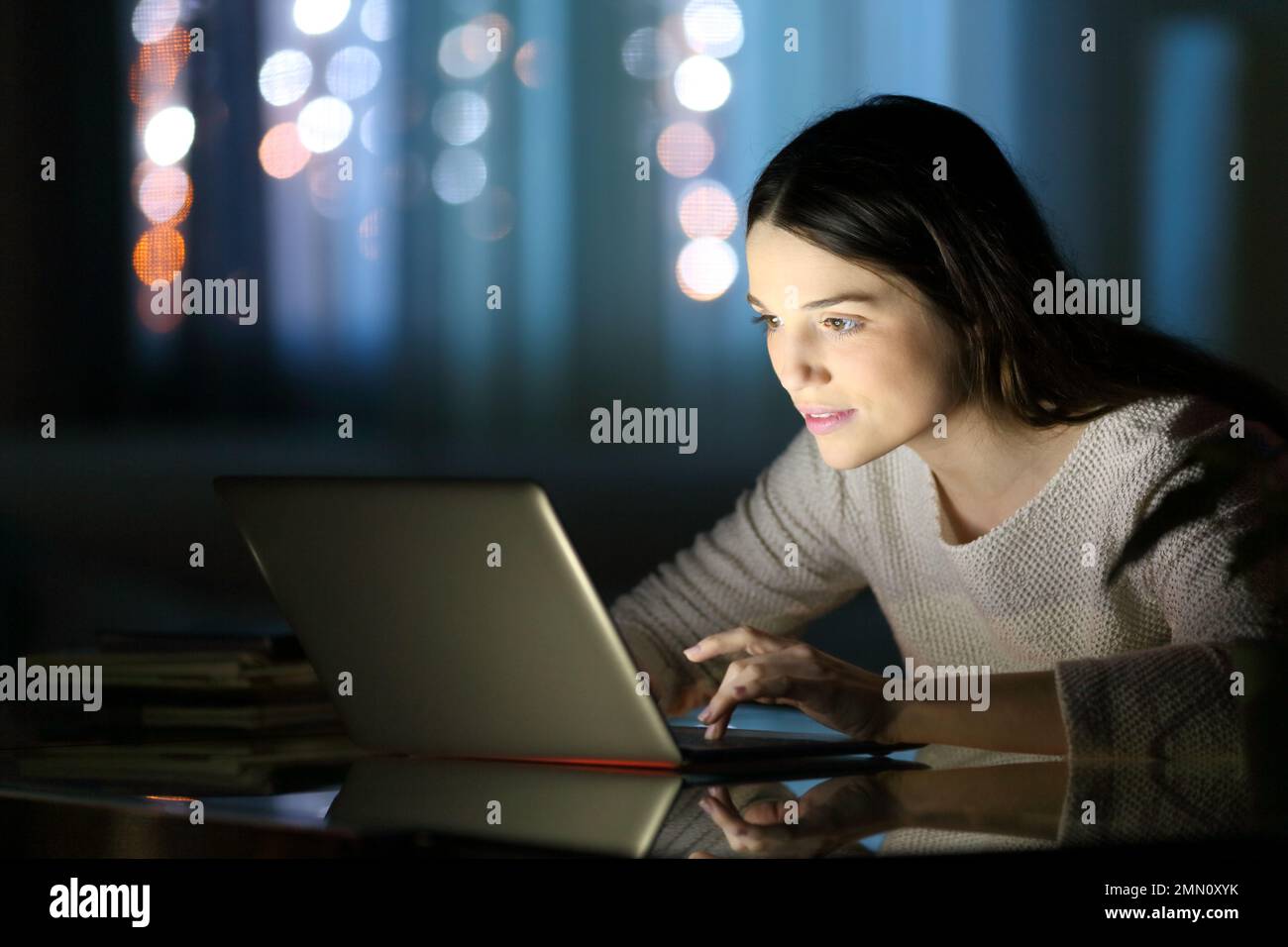Woman using laptop in the night at home Stock Photo