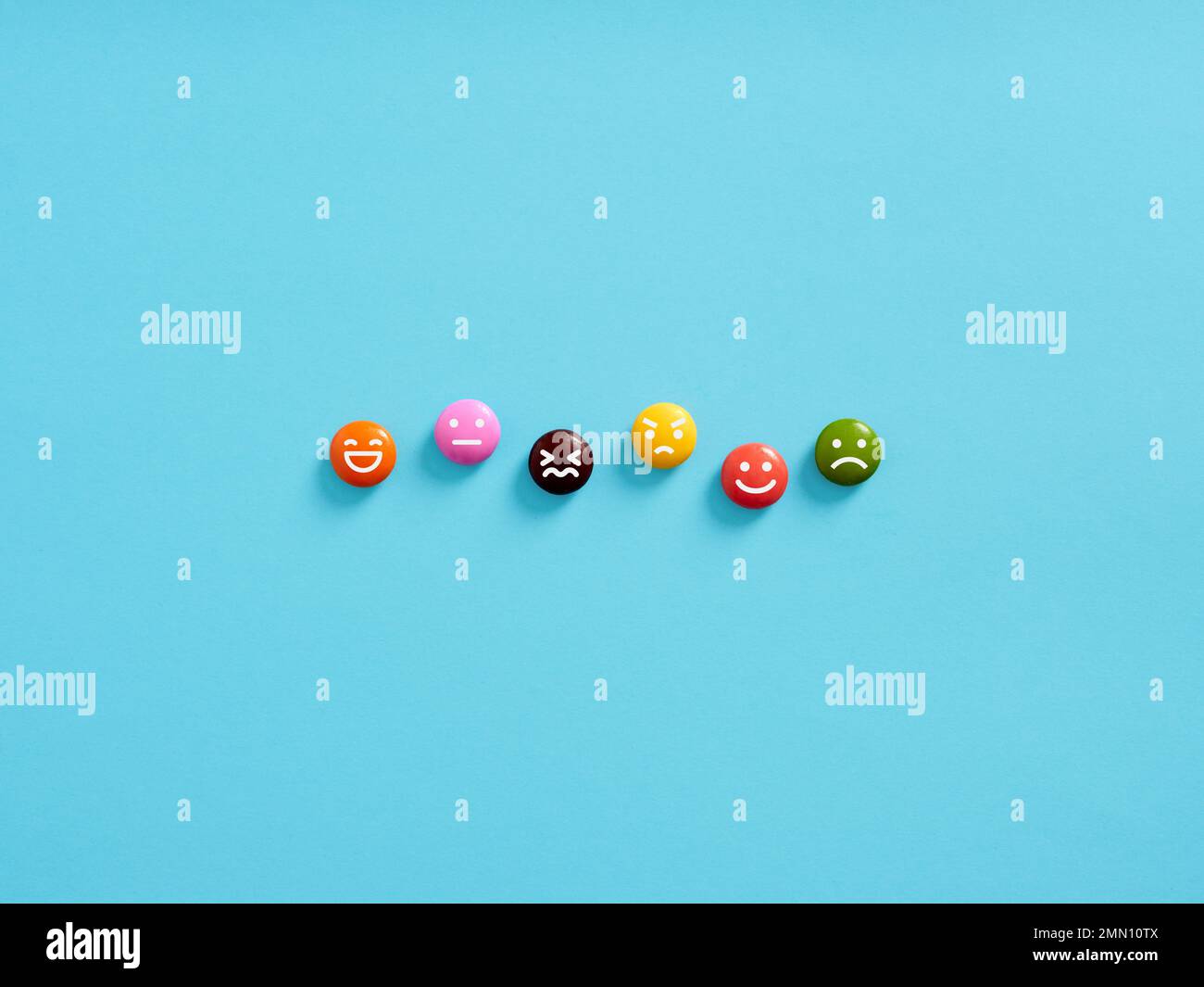 Joy, serenity, anger, happiness, sadness, delight, hate. Psychological mood swings. Variety of human emotions represented by emoticons on colored cand Stock Photo