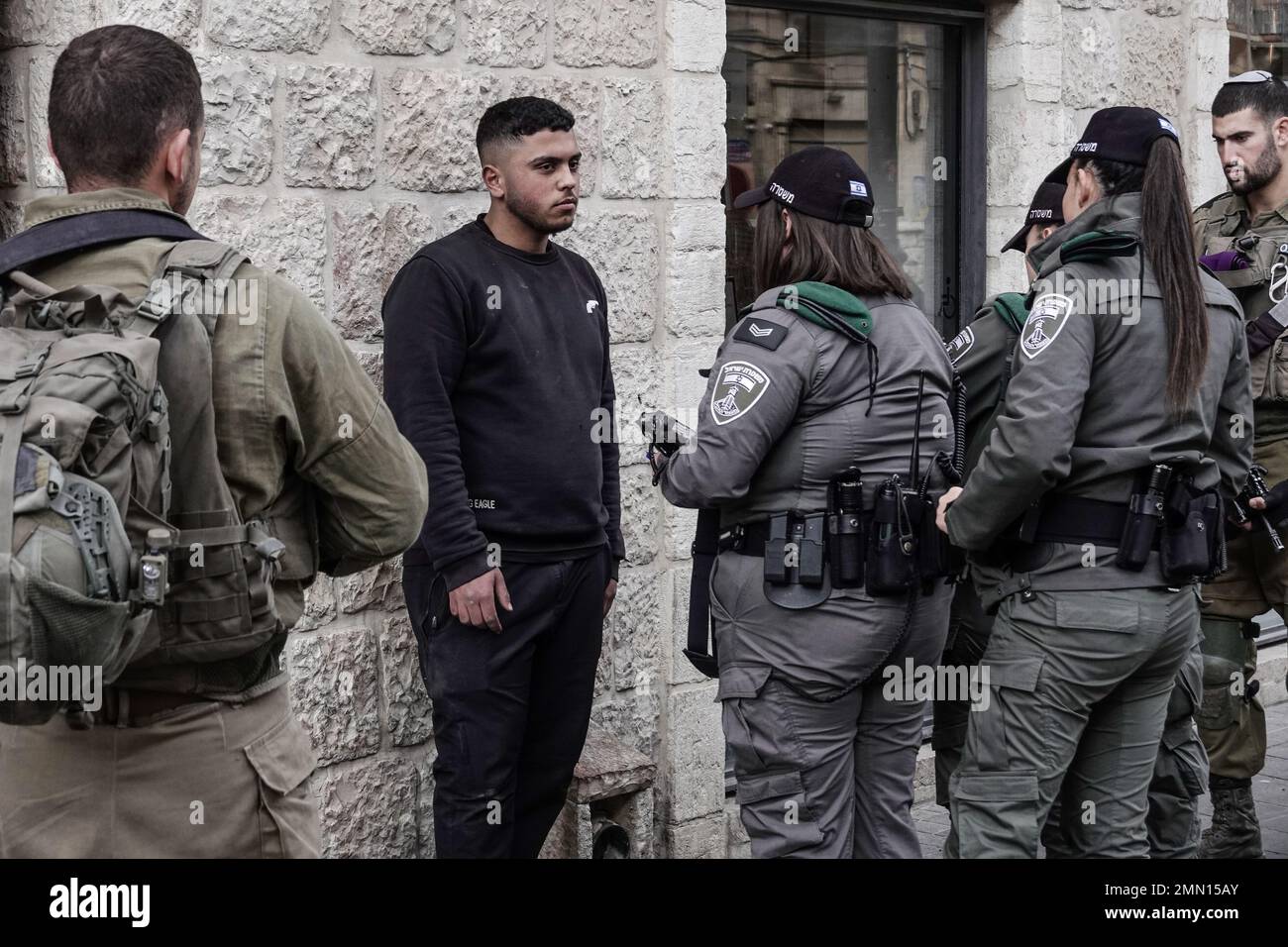 Jerusalem, Israel. 30th Jan, 2023. Border Police forces with reinforcements from the IDF Givati Brigade in purple berets, on heightened security, detain and question a young Palestinian man wearing a black sweatshirt with an image of a revolver. Israel raised the terror alert to the highest level and deployed additional battalions to Jerusalem and the West Bank amid an escalation of violence following two terrorist shootings in the capital. Seven Israelis have been murdered and five injured. Credit: Nir Alon/Alamy Live News Stock Photo