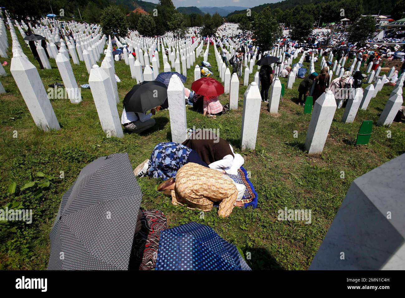 Bosnian Muslim women pray during a funeral ceremony for the victims of