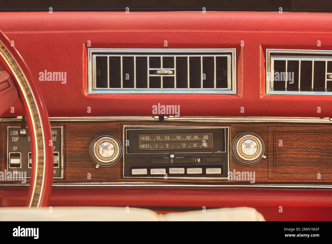 Old car radio inside a red classic American car with chrome and wooden dashboard Stock Photo