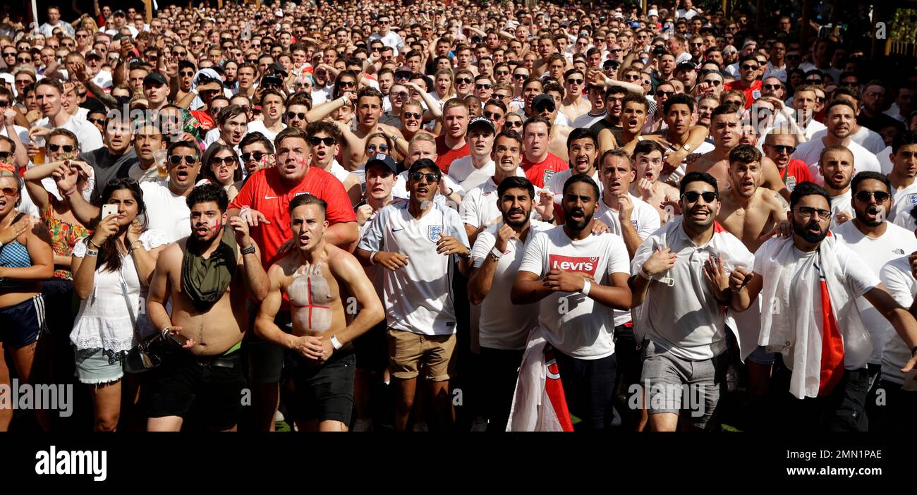 England soccer fans stand poised to react as England's Harry Maguire scores their first goal as