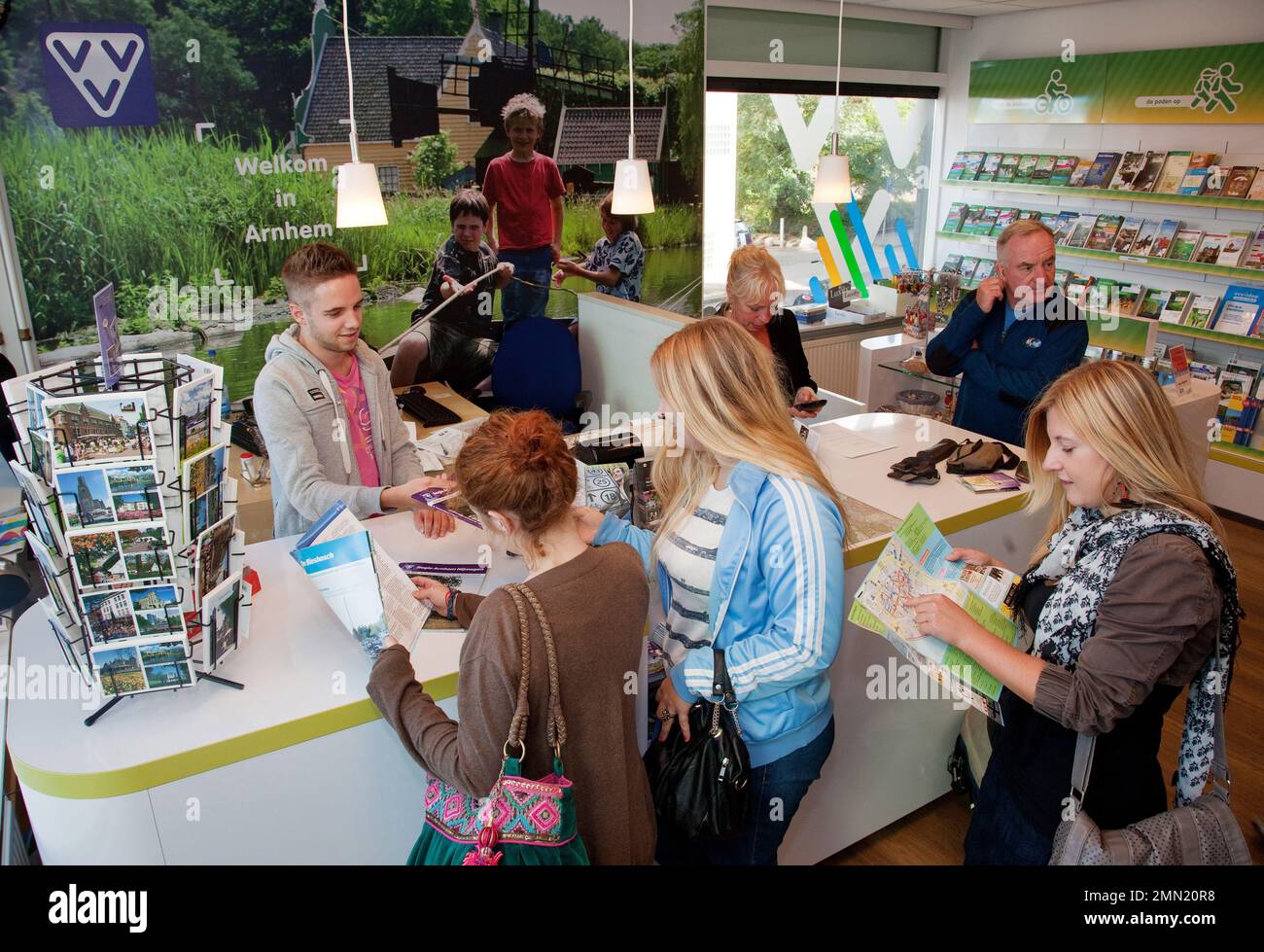 Europe, Netherlands, Arnhem. Tourists at the tourist office (VVV) asking for maps of the city. Stock Photo