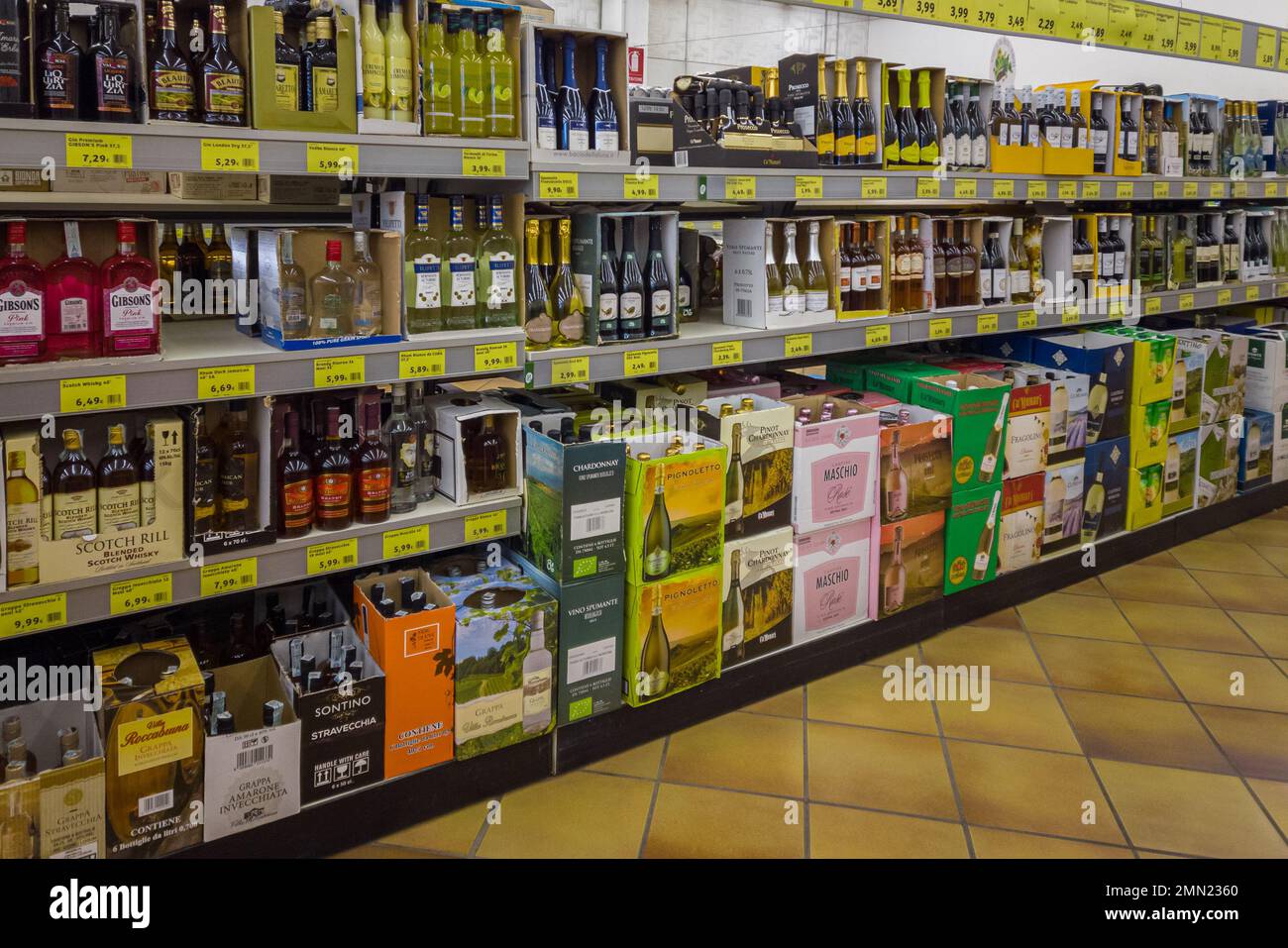 Italy - January 28, 2023: bottles of wine and spirits in cardboard boxes for sale on Italian supermarket discout store shelves Stock Photo
