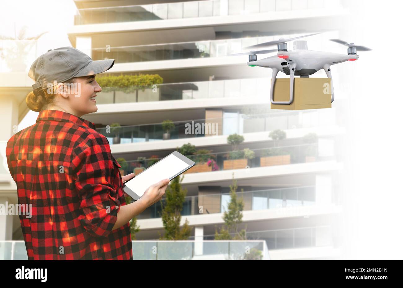 Woman worker holding tablet and controlling delivery drone. Concept Stock Photo