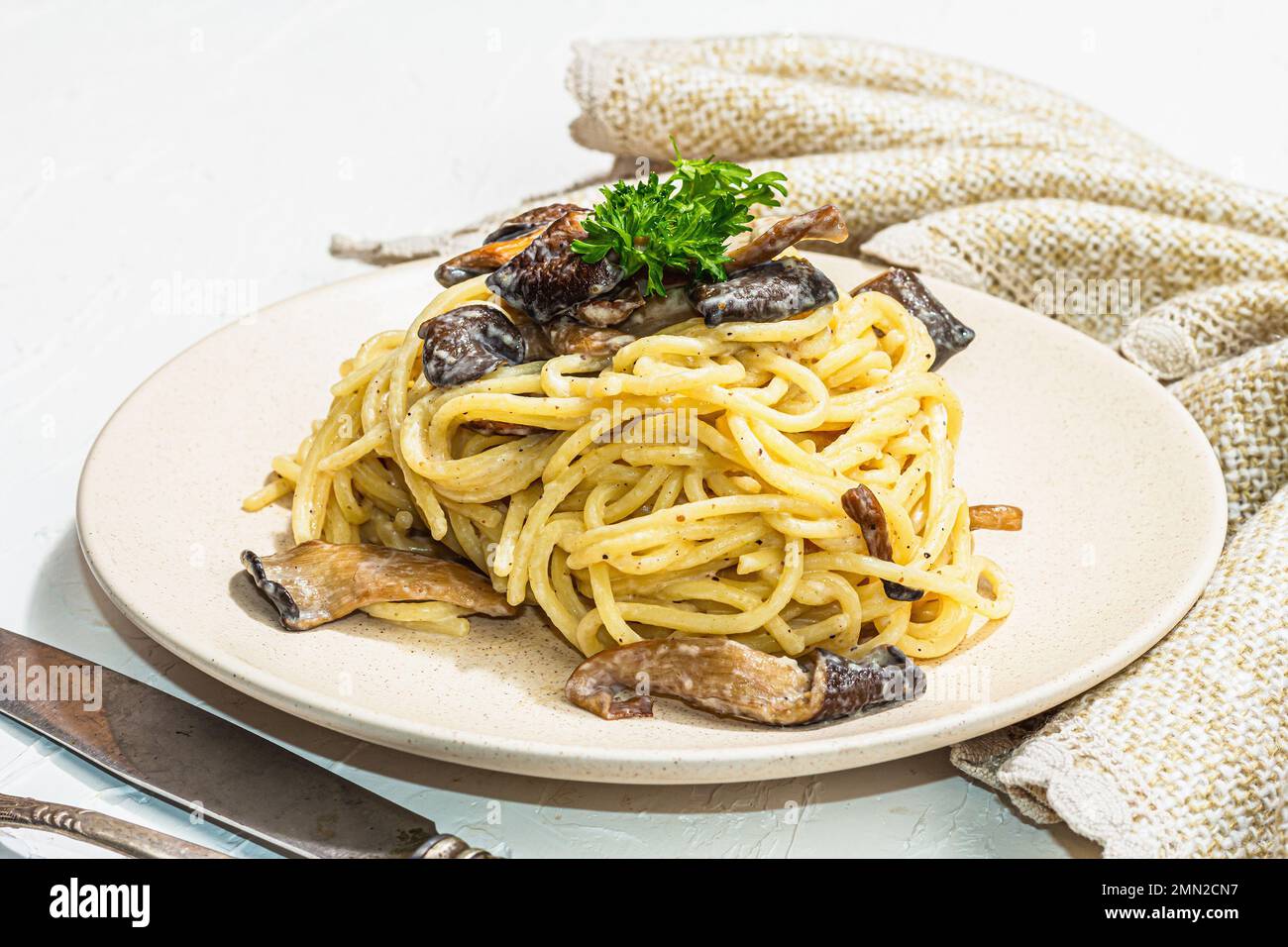 Spaghetti pasta with oyster mushrooms, creamy sauce and parsley