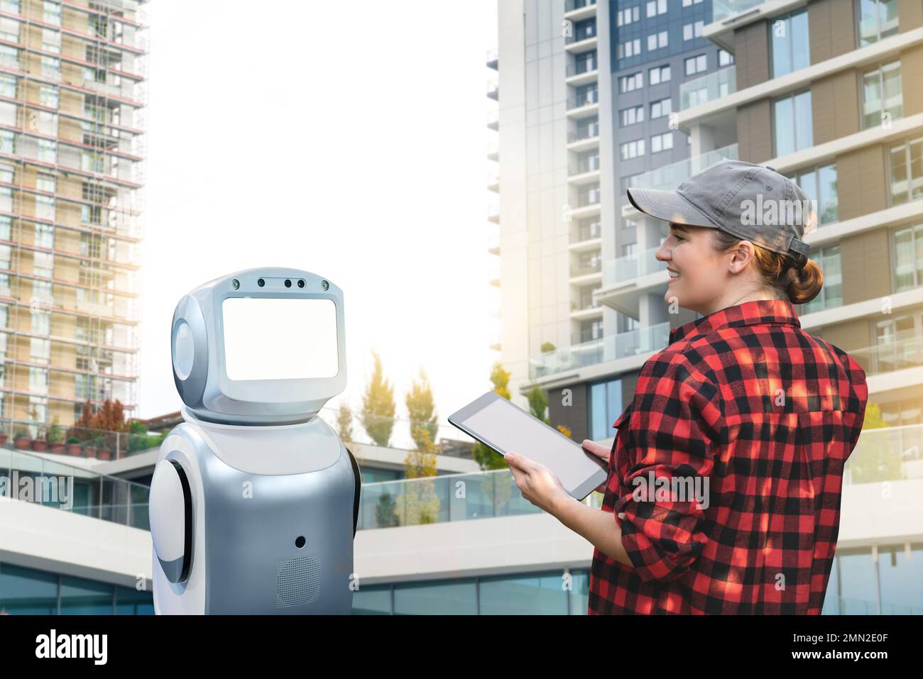 Robot assistant with woman worker in front of building. Concept, idea Stock Photo