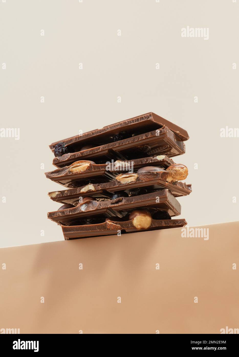 Stack of chocolate with nuts on a beige background Stock Photo