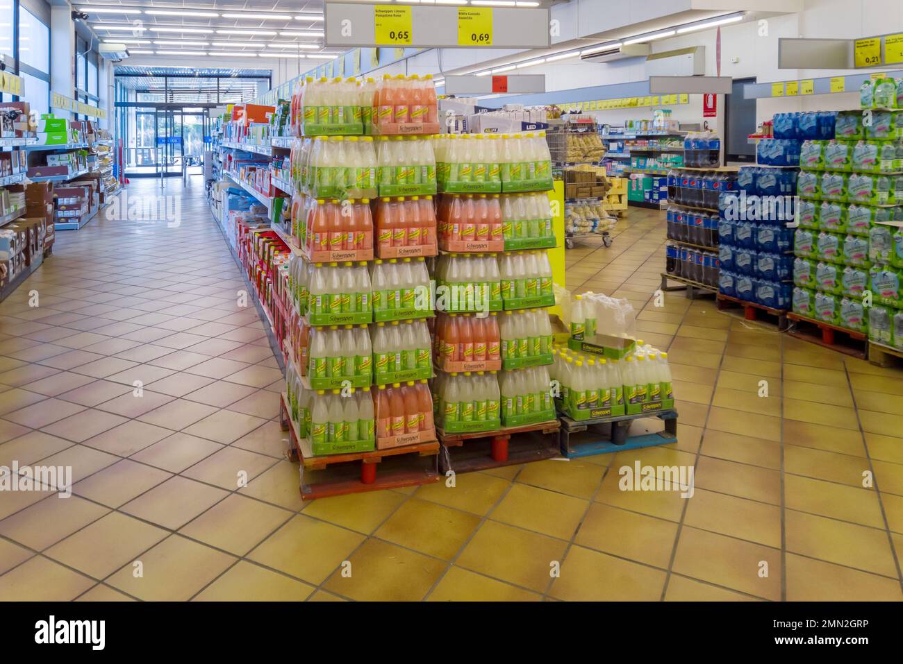 Fossano, Italy - January 28, 2023: pet bottles Shweppes soft drinks and water on pallet in Italian INS discount store, INS is Italian supermarket chai Stock Photo