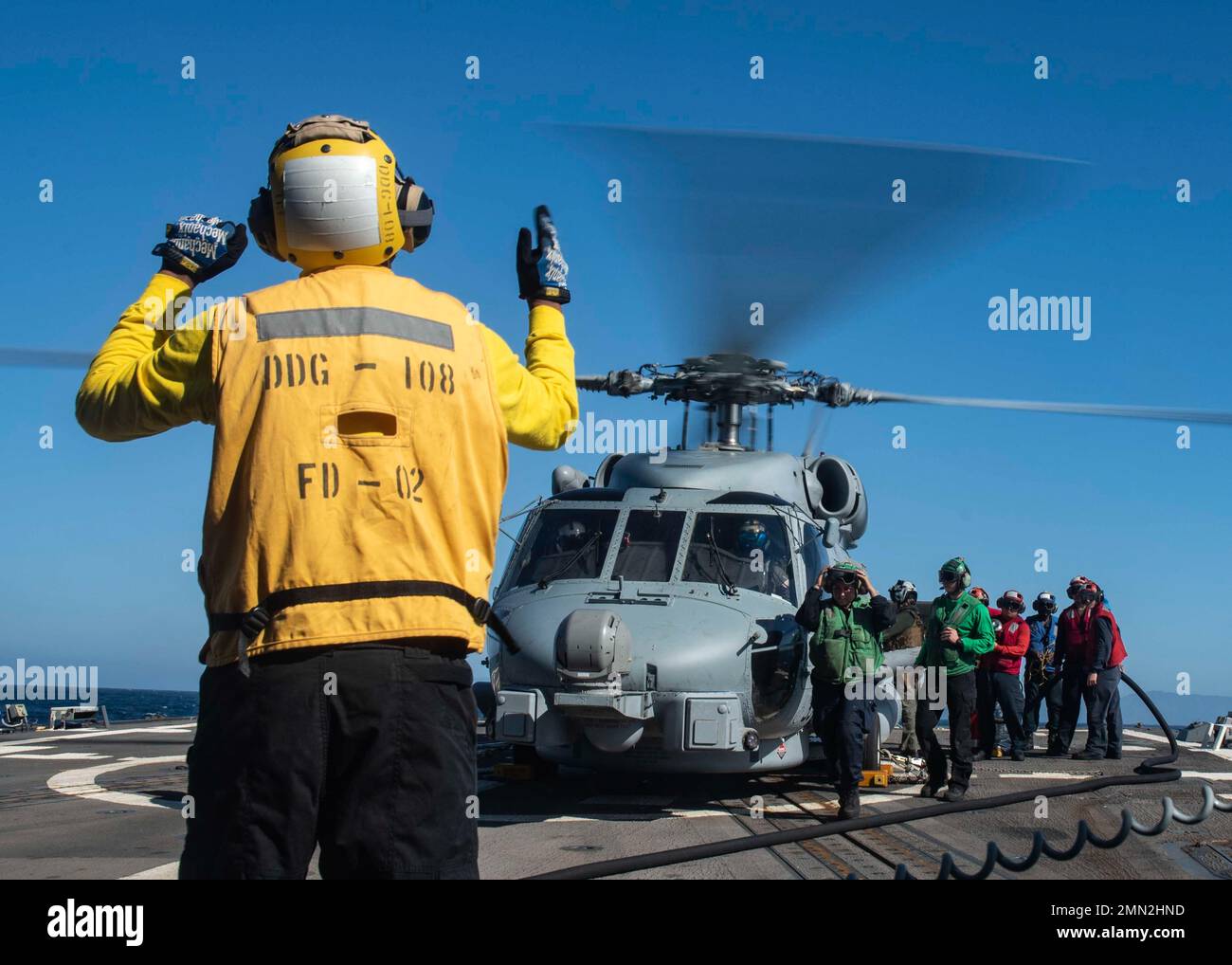 220925-N-XK462-1029 PACIFIC OCEAN (Sept. 25, 2022) U.S. Sailors refuel an MH-60R Sea Hawk helicopter from the “Easyriders” of Helicopter Maritime Strike Squadron (HSM) 37, on the flight deck of the Arleigh Burke-class guided missile destroyer USS Wayne E. Meyer (DDG 108). Wayne E. Meyer is operating with Nimitz Carrier Strike Group in preparation for an upcoming deployment. Stock Photo