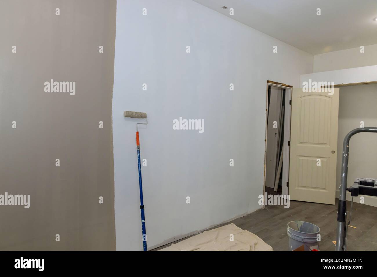 Painted wall with painting equipments and stepladder near wall in empty room Stock Photo