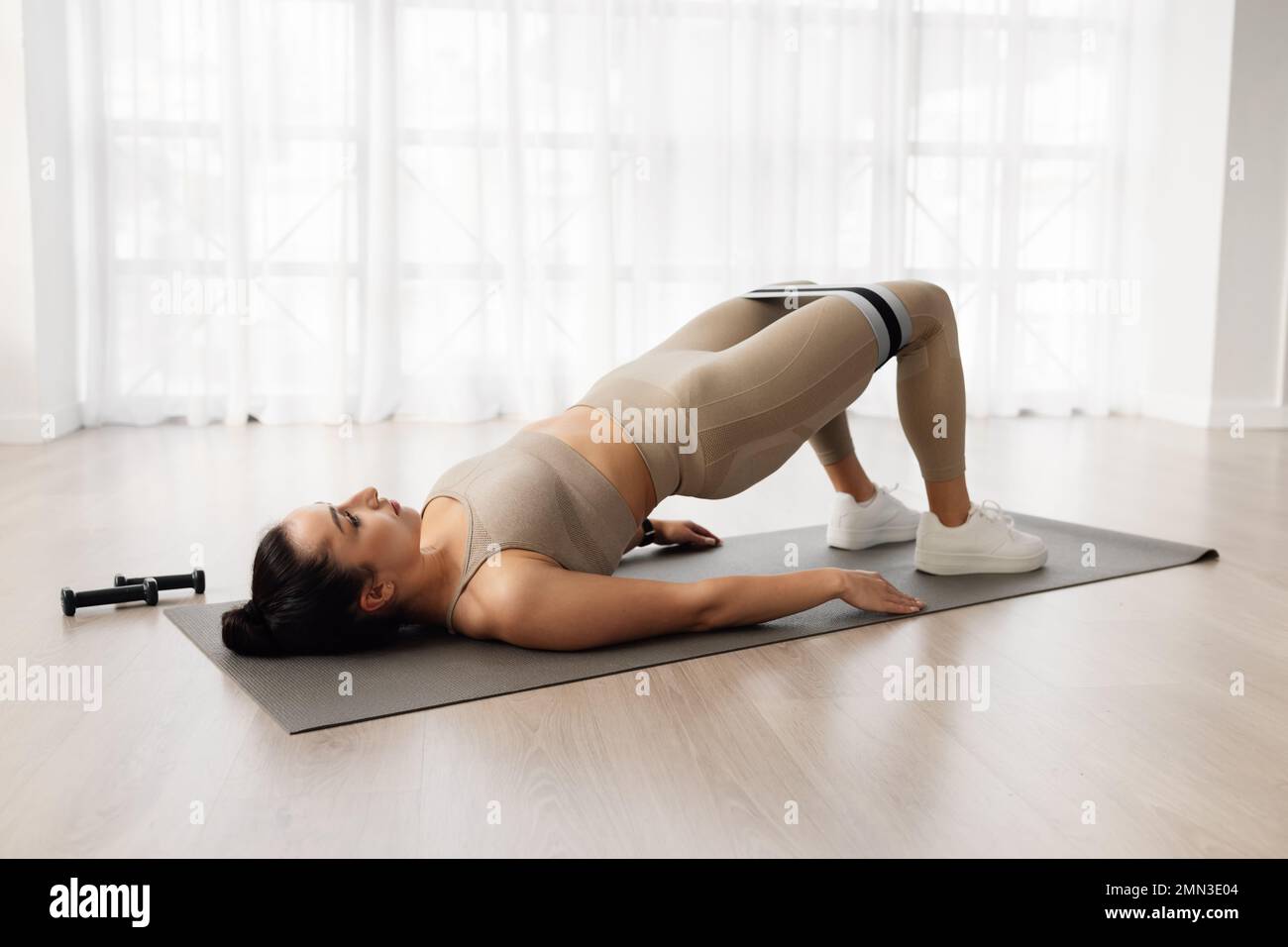 Well-fit sporty young woman exercising at home Stock Photo