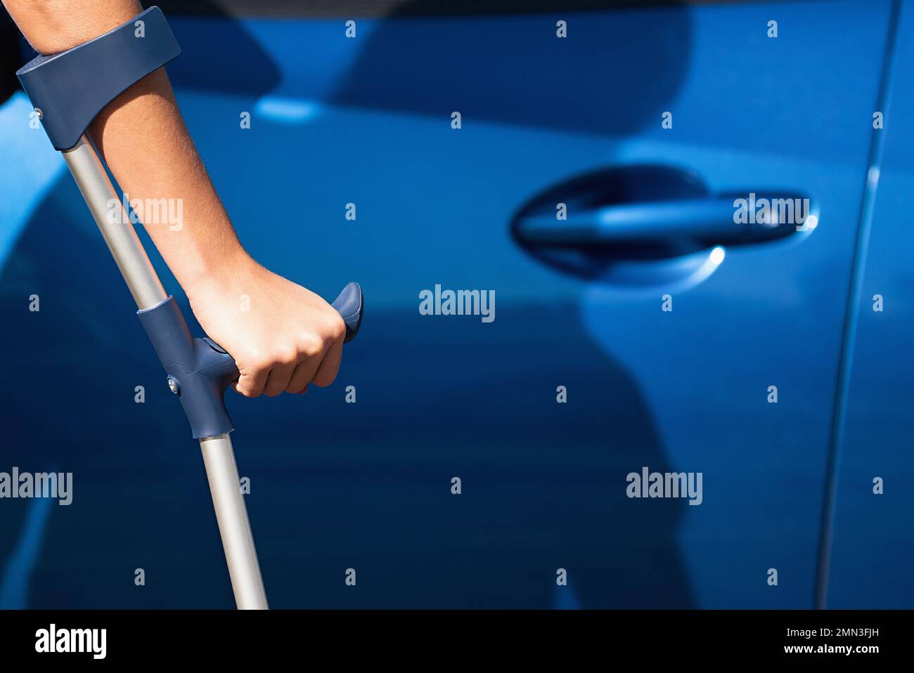 Handicapped woman with crutches opening door of a car, travel and