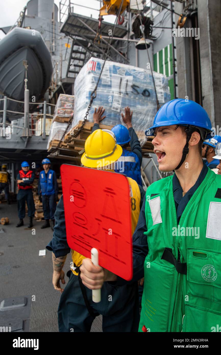 SEA OF JAPAN (Sept. 27, 2022) Personnel Specialist Seaman Cameron Stine, from Ft. Worth, Texas, signals USNS Yukon (T-AO-202) while aboard Ticonderoga-class guided-missile cruiser USS Chancellorsville (CG 62) during a replenishment-at-sea in the Sea of Japan on Sept. 27, 2022. Chancellorsville is forward-deployed to the U.S. 7th Fleet in support of security and stability in the Indo-Pacific and is assigned to Commander, Task Force 70, a combat-ready force that protects and defends the collective maritime interest of its allies and partners in the region. Stock Photo