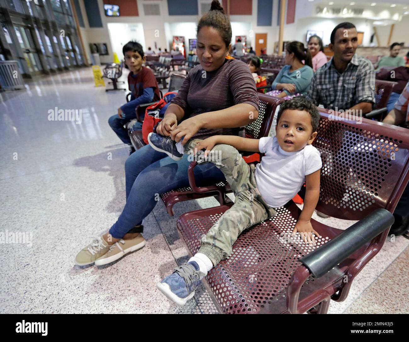 Immigrant Patricia Lozano, from Honduras, ties her son's, Diego, shoe