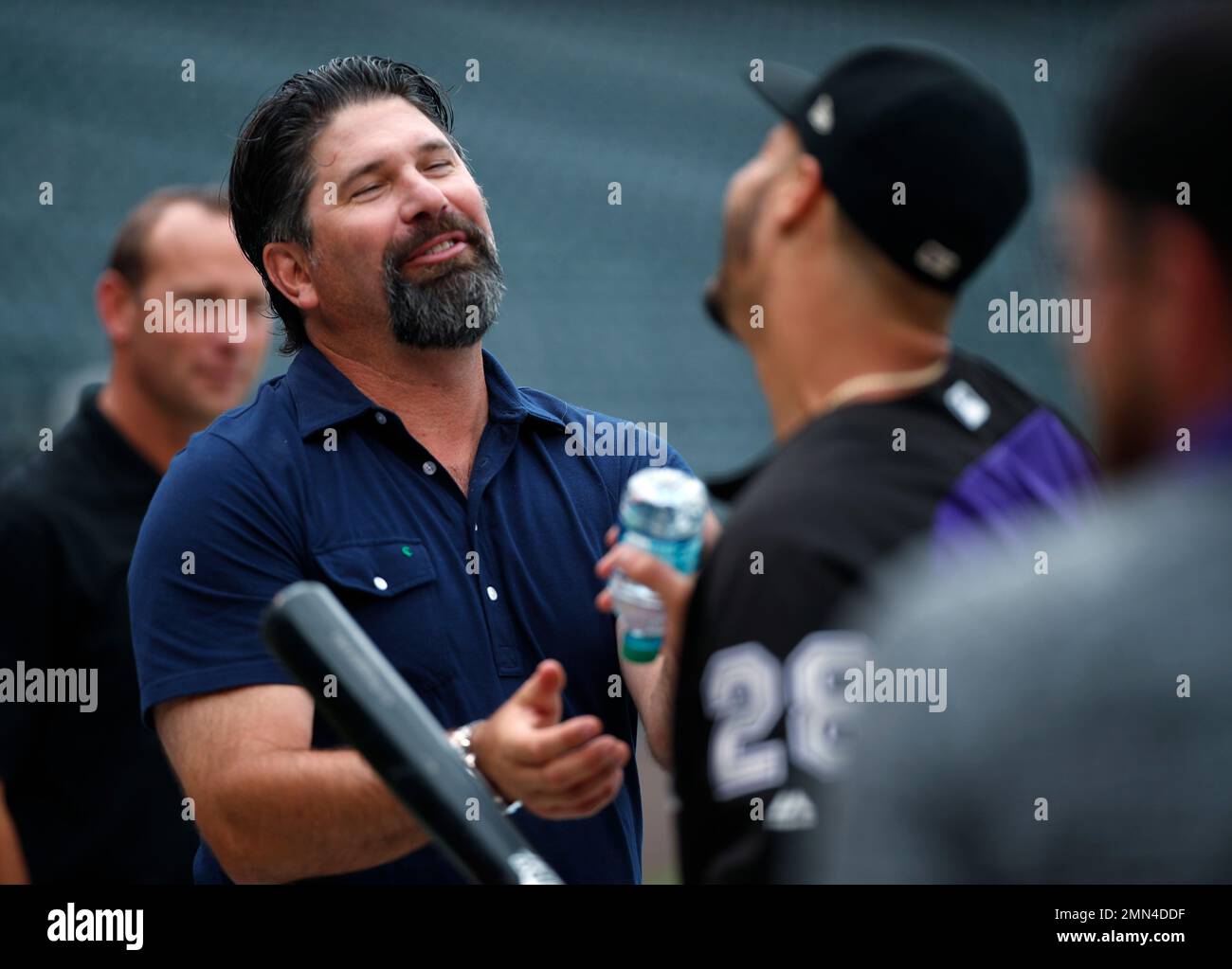 Retired Colorado Rockies first baseman Todd Helton, left, jokes with