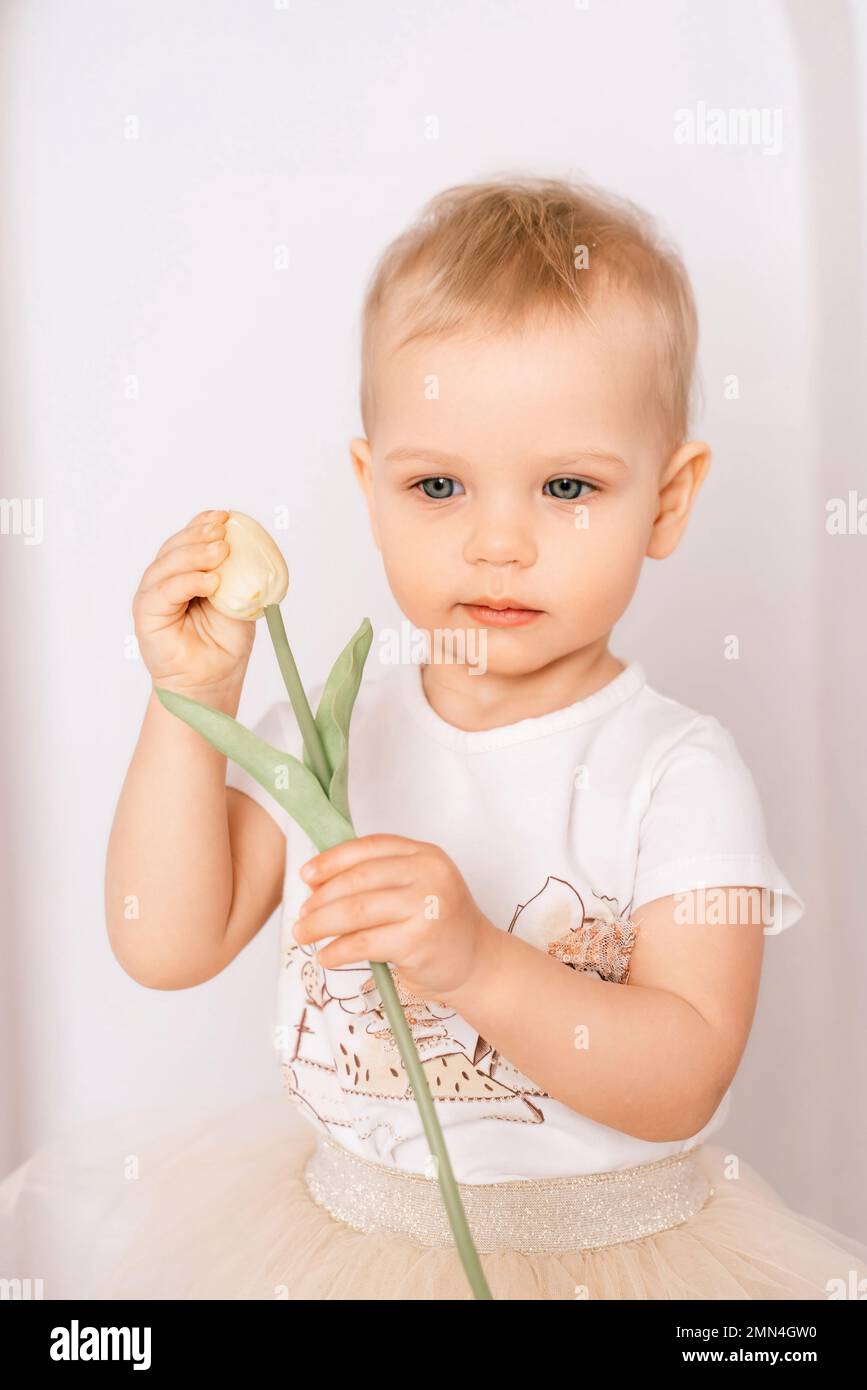 Baby girl elegant dress. A oneyearold girl in a puffy skirt and a white Tshirt poses against
