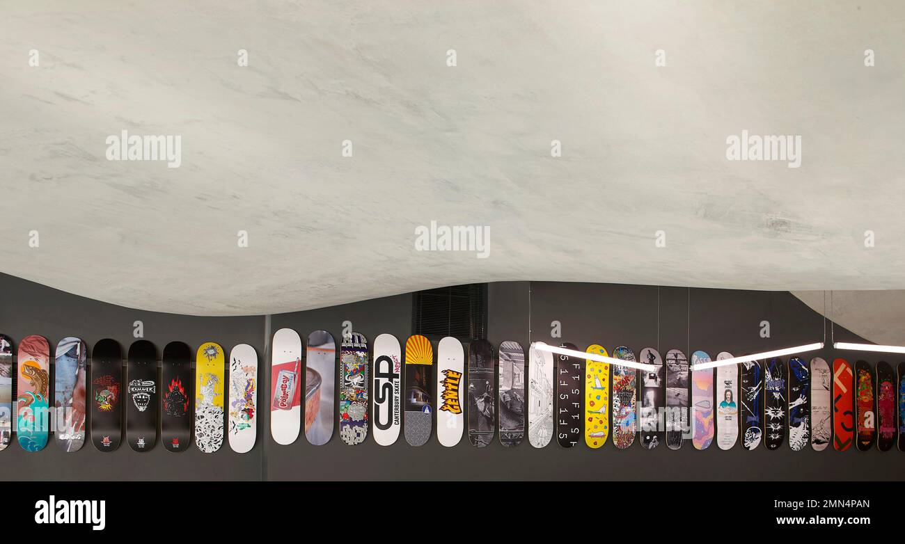 Display of skateboards below undulating ceiling. F51 Skatepark, Folkestone, United Kingdom. Architect: Hollaway Studio, 2022. Stock Photo