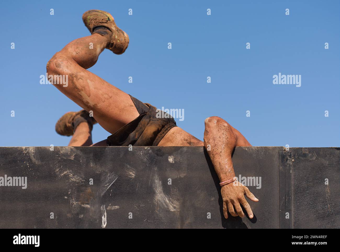 Mud race runners running over obstacles extreme sport Stock Photo