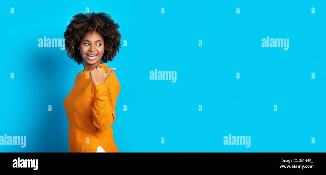Excited black young woman showing empty space for ad Stock Photo