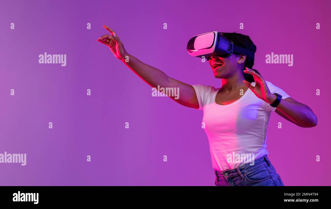 Virtual Reality Experience. Excited Black Woman Playing Video Game In VR Glasses Stock Photo