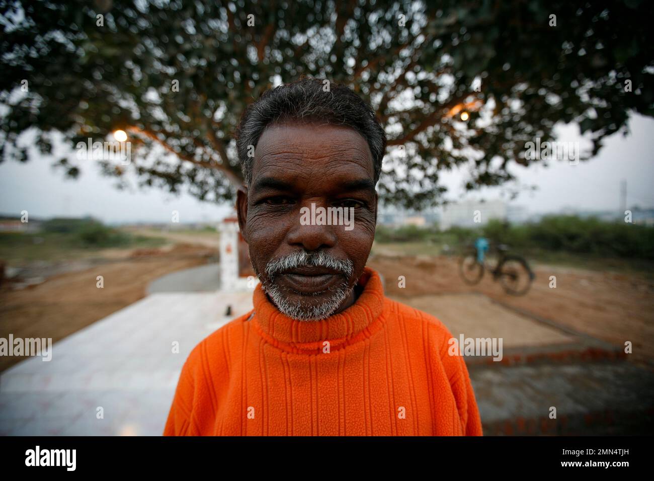 An old Indian man and a road side temple. Stock Photo