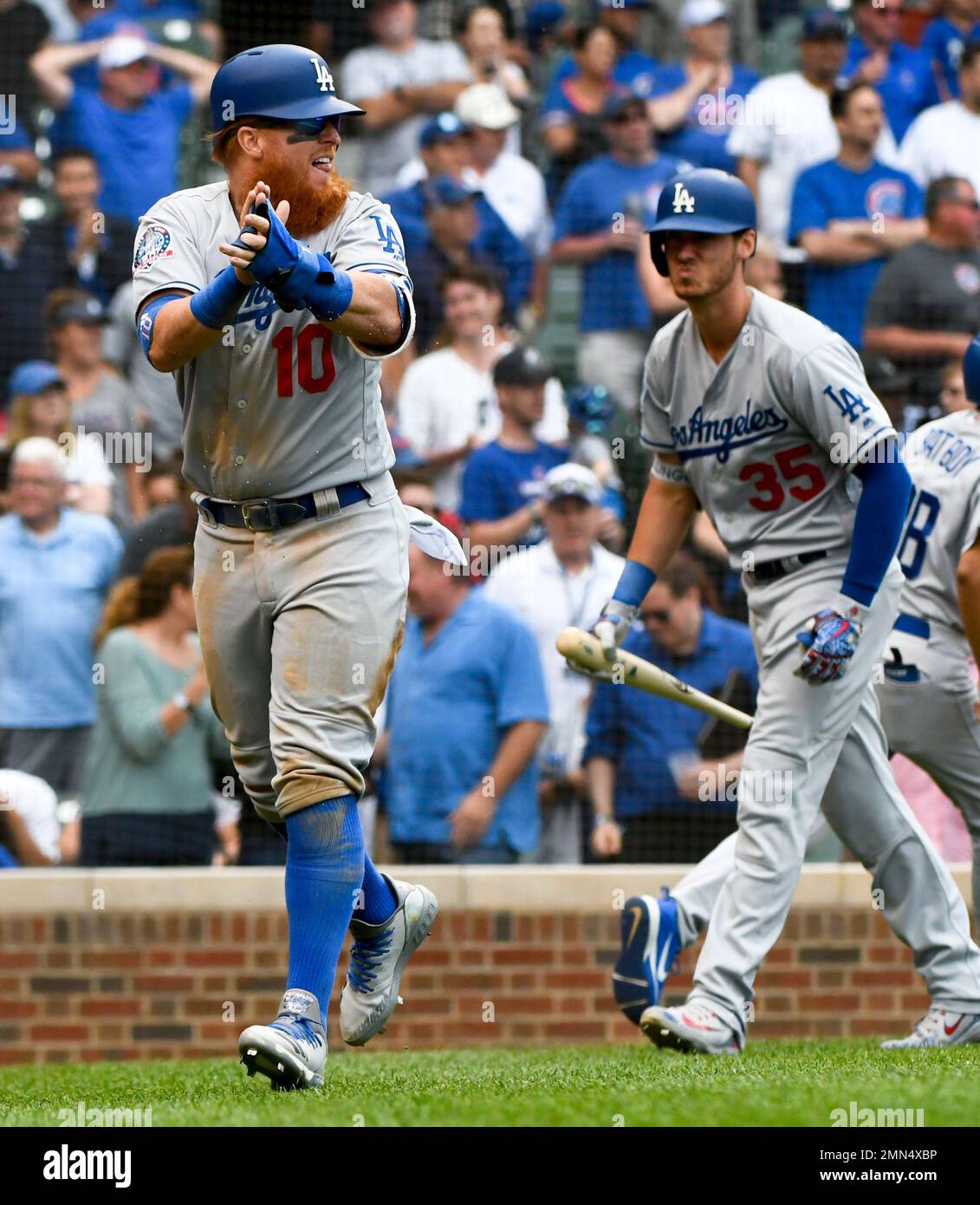 Los Angeles Dodgers' Justin Turner (10) claps towards Kyle Farmer after he  scores during the ninth inning of a baseball game against the Chicago Cubs  on Tuesday, June 19, 2018, in Chicago. (