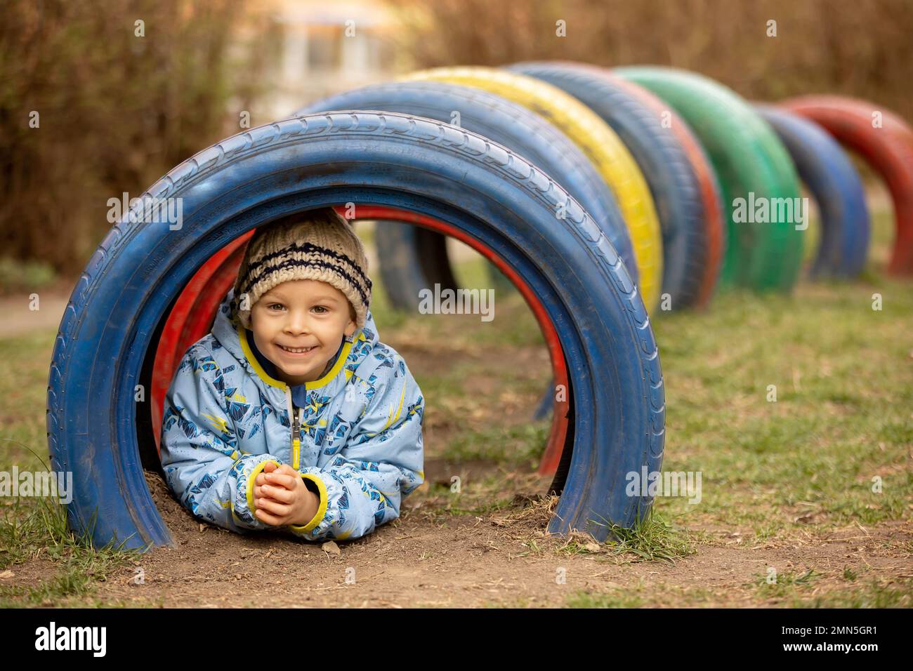Springtime Playground Sweet preschool child, cute boy, playing on the playground in the park ...