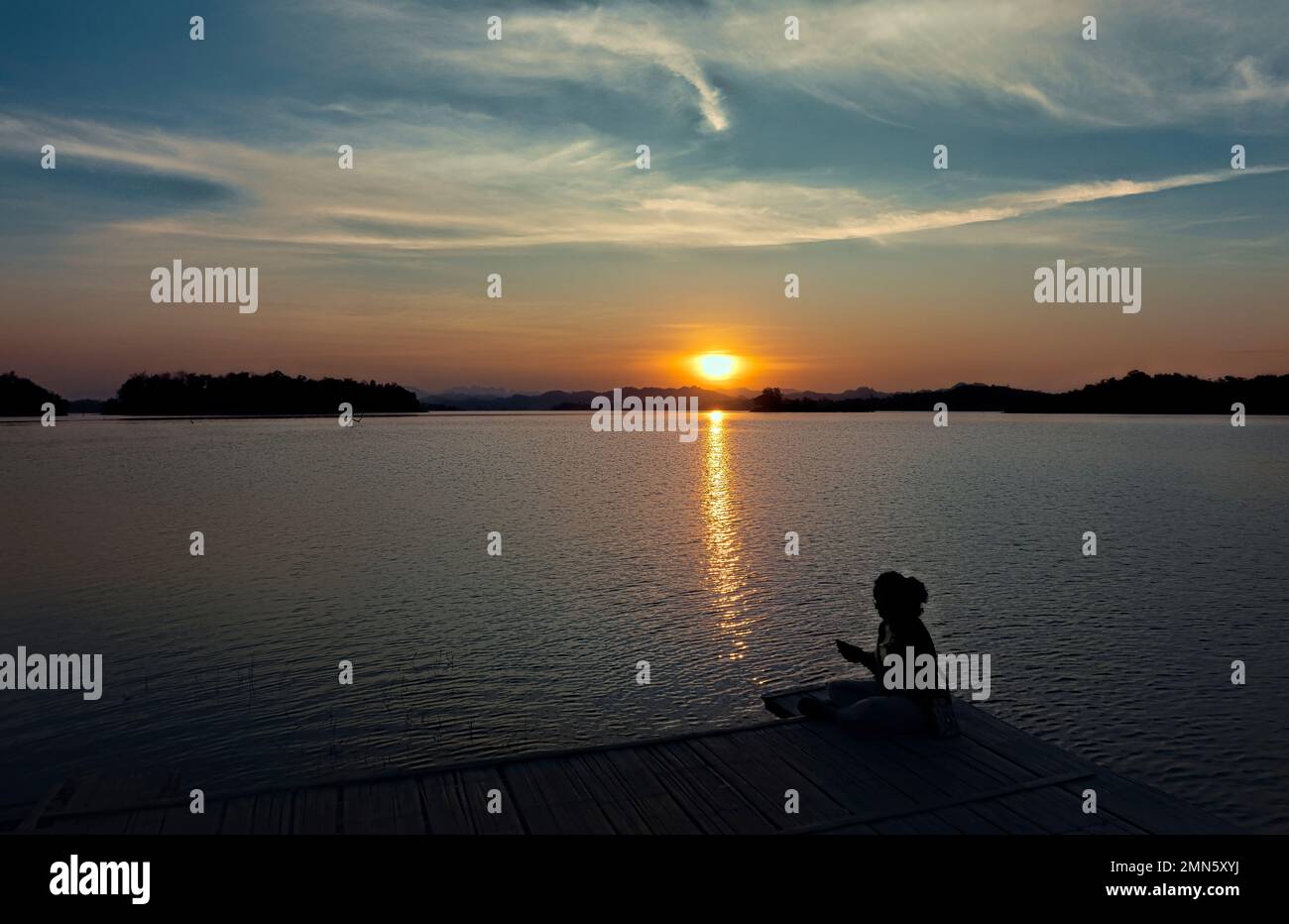 Watching the sunset along the Vajiralongkorn Reservoir, Khao Laem National Park, Kanchanaburi, Thailand Stock Photo