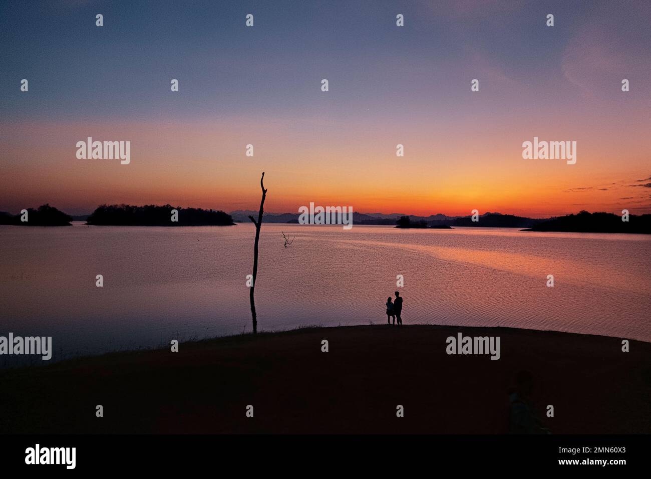 Watching the sunset along the Vajiralongkorn Reservoir, Khao Laem National Park, Kanchanaburi, Thailand Stock Photo