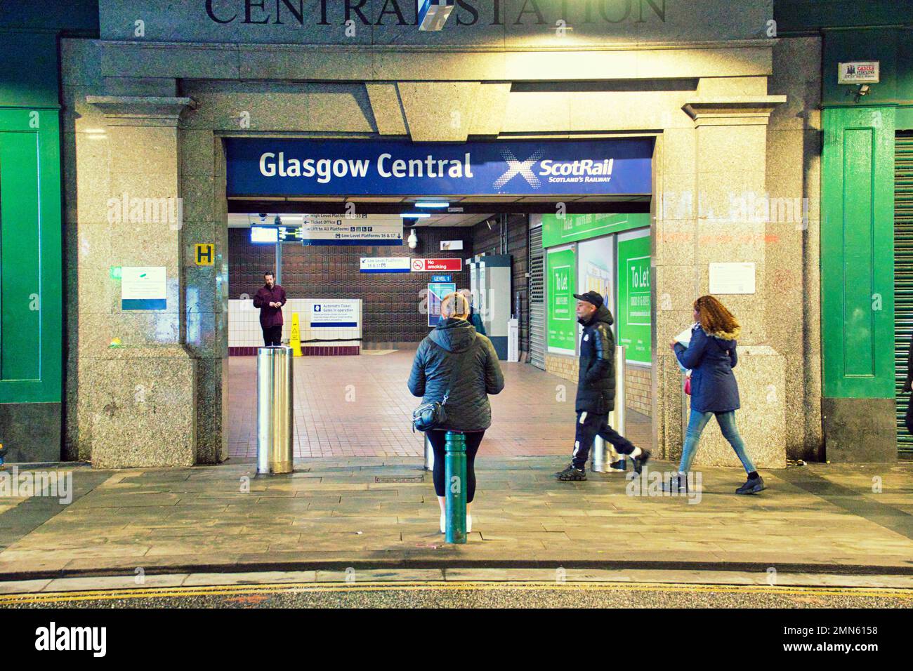 Glasgow, Scotland, UK 29tht January, 2023. UK Weather:   Cold and wet saw sunny style mile as the entrance to central station under the highlanders umbrella on argyle street provides shelter from the rain to one traveller.t. Credit Gerard Ferry/Alamy Live News Stock Photo