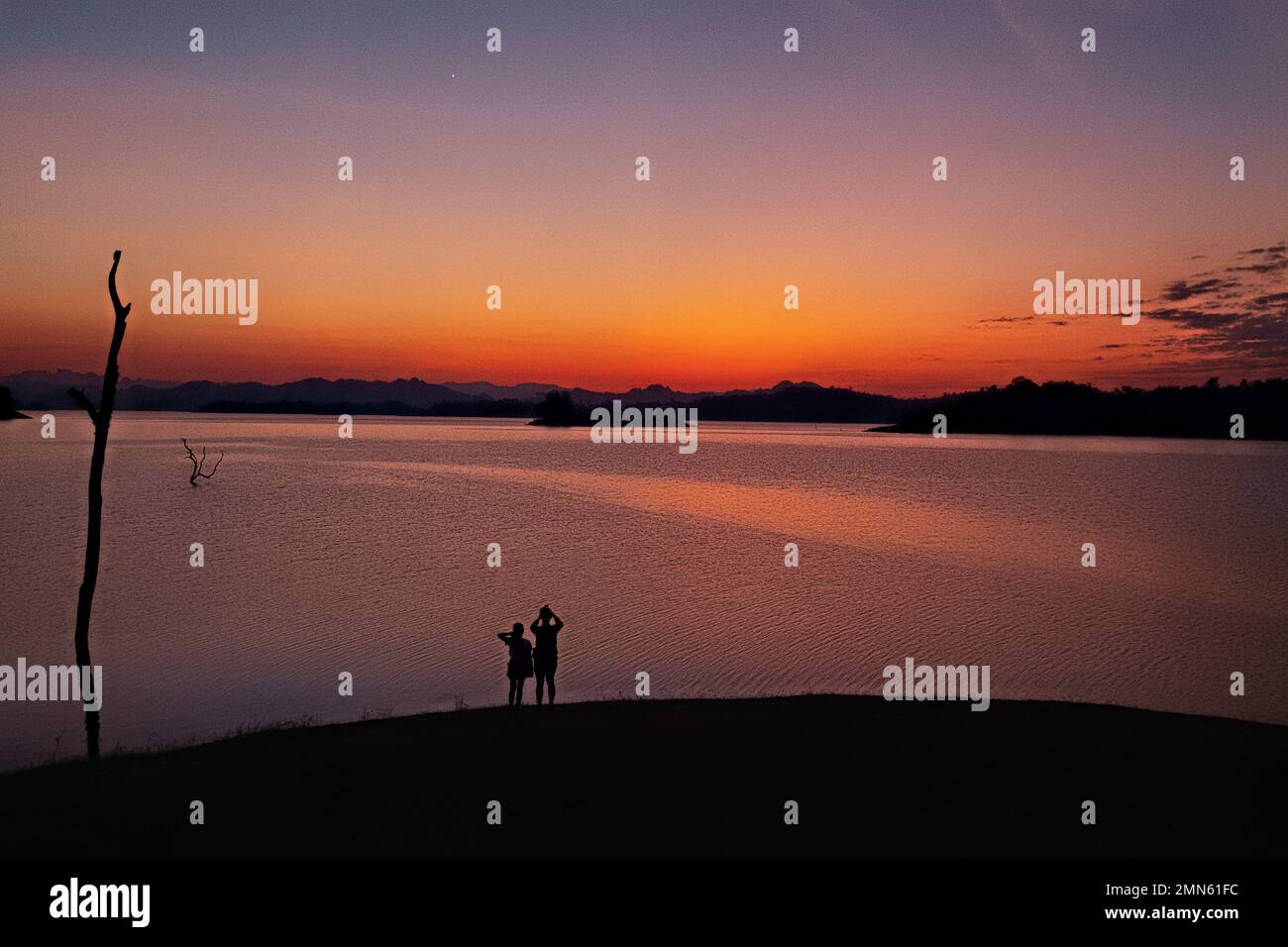 Watching the sunset along the Vajiralongkorn Reservoir, Khao Laem National Park, Kanchanaburi, Thailand Stock Photo