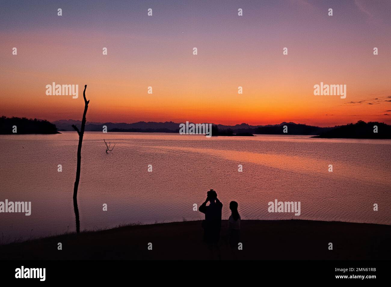Watching the sunset along the Vajiralongkorn Reservoir, Khao Laem National Park, Kanchanaburi, Thailand Stock Photo
