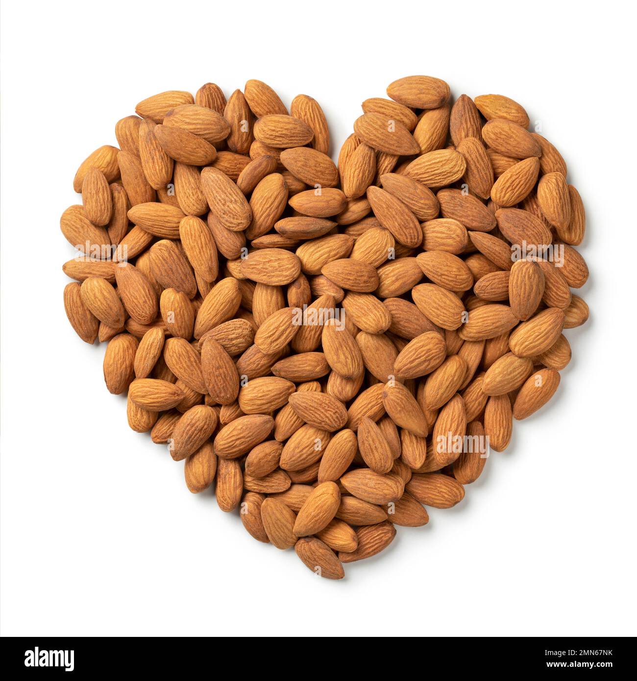 Almonds in heart shape isolated on white background Stock Photo