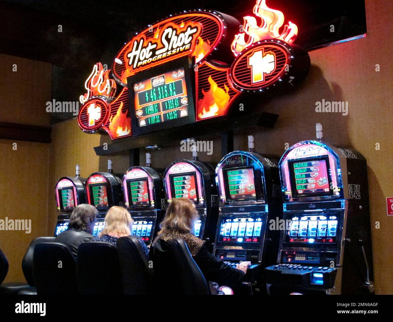 This April 20, 2018 photo shows gamblers playing slot machines at