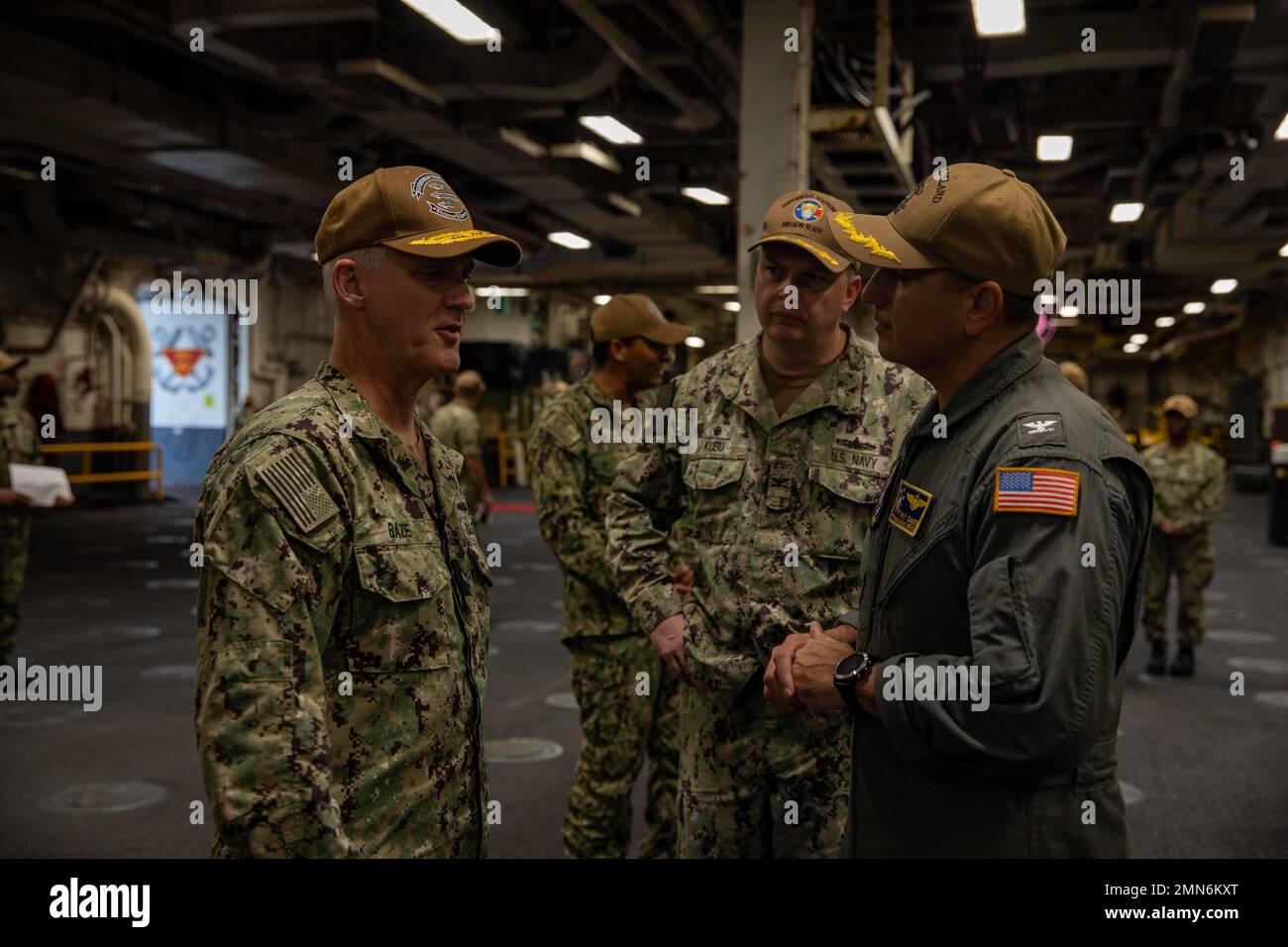 SAN DIEGO (Sept. 29, 2022) – Rear Adm. Wayne Baze, commander, Expeditionary Strike Group 3, left, speaks to Capt. Tony Chavez, commanding officer of amphibious assault ship USS Makin Island (LHD 8), right, and Capt. Justin Kubu, commodore of Amphibious Squadron SEVEN, middle, during a North Atlantic Treaty Organization (NATO) visit aboard Makin Island, Sept. 29. The visit aims to provide an opportunity for NATO parliamentarians to learn more about the US-Indo Pacific policy as well as US military, technological and economic structure. Makin Island is homeported in San Diego. Stock Photo