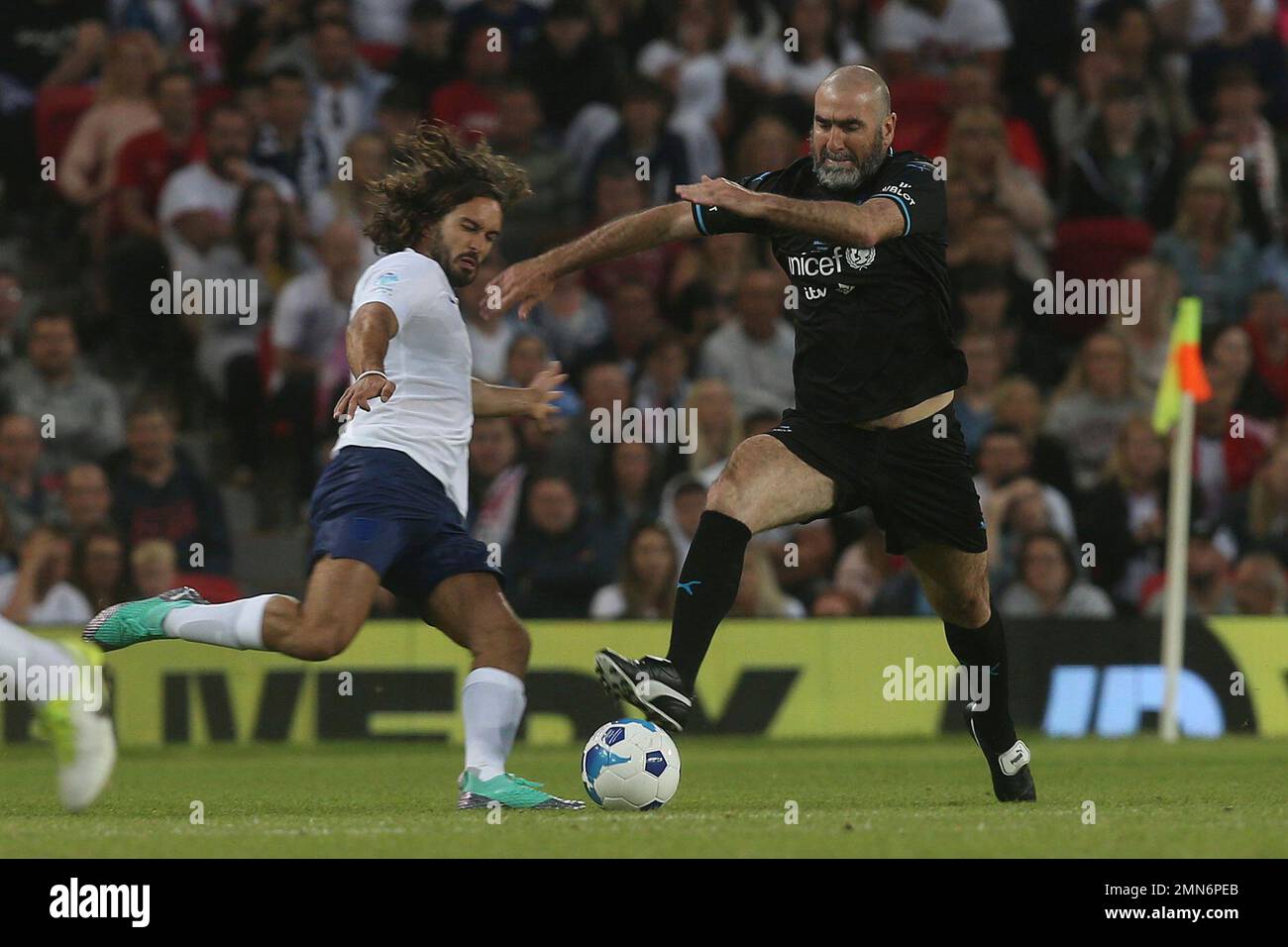 Former footballer Eric Cantona in action on the pitch at Old Trafford ...