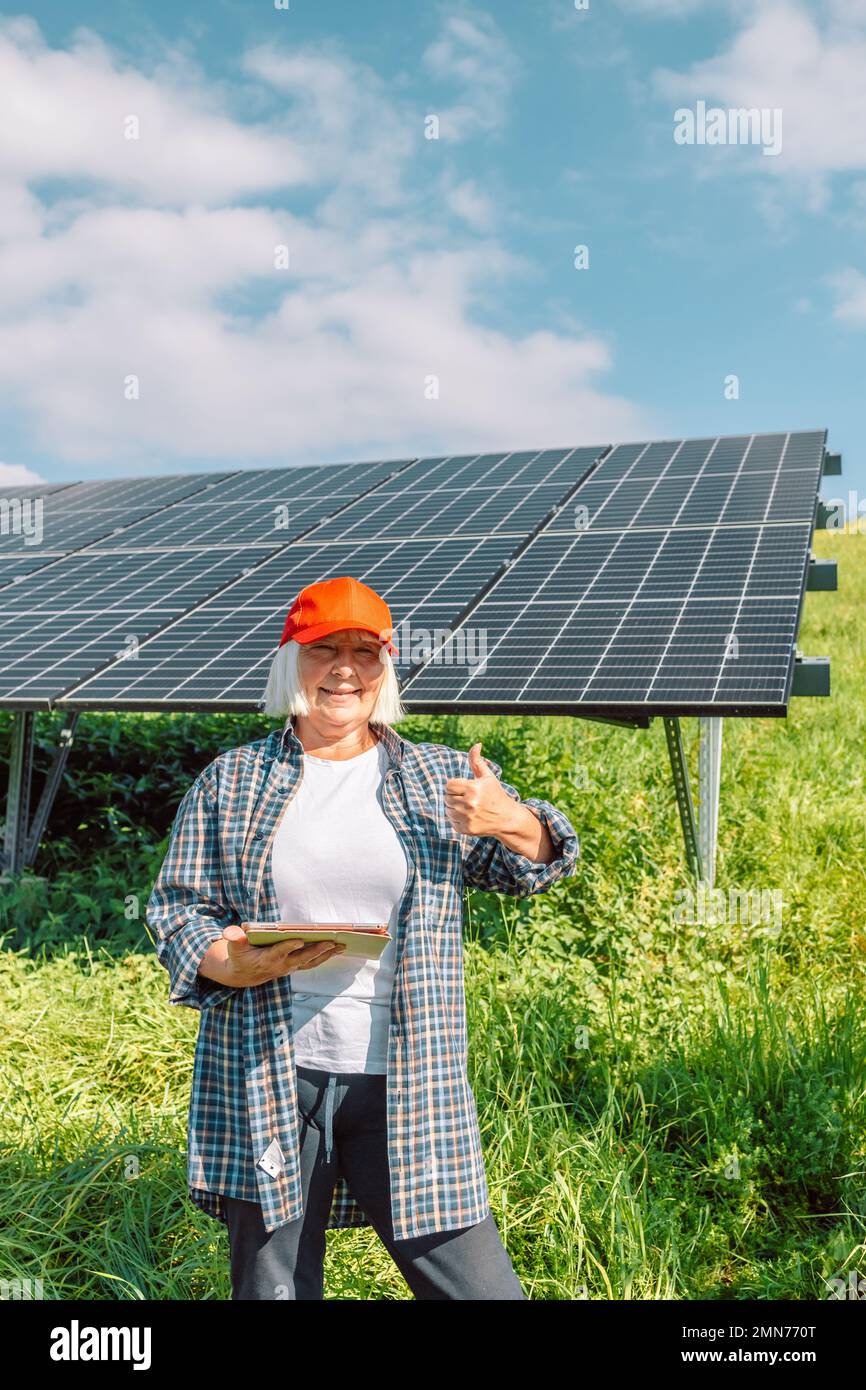 Tablet Using Solar Panel Businesswoman engineer using tablet near solar panels. Renewable energy ...