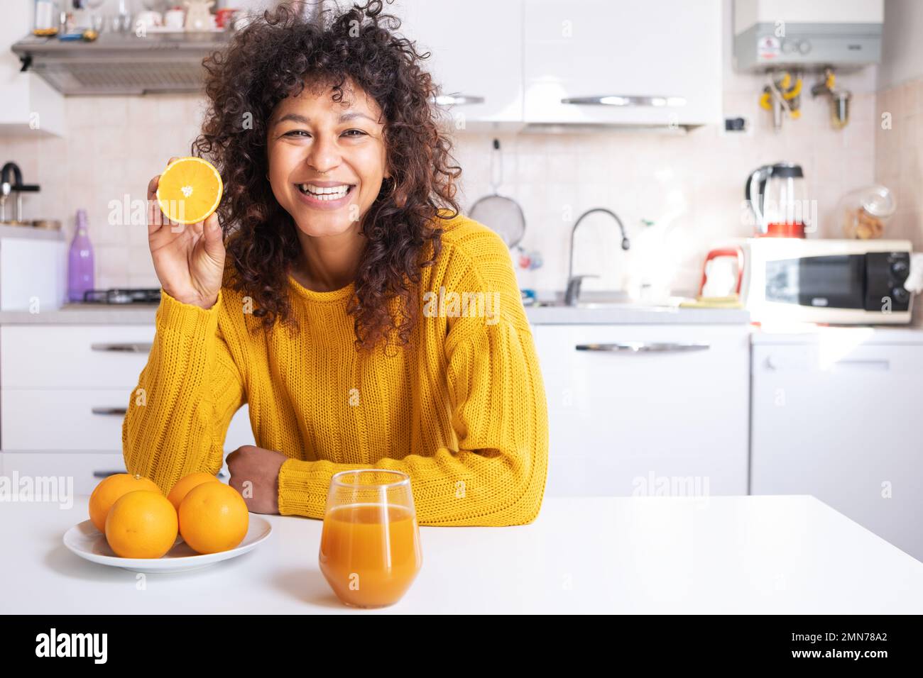 Happy black woman drinking healthy extract orange juice Stock Photo Alamy