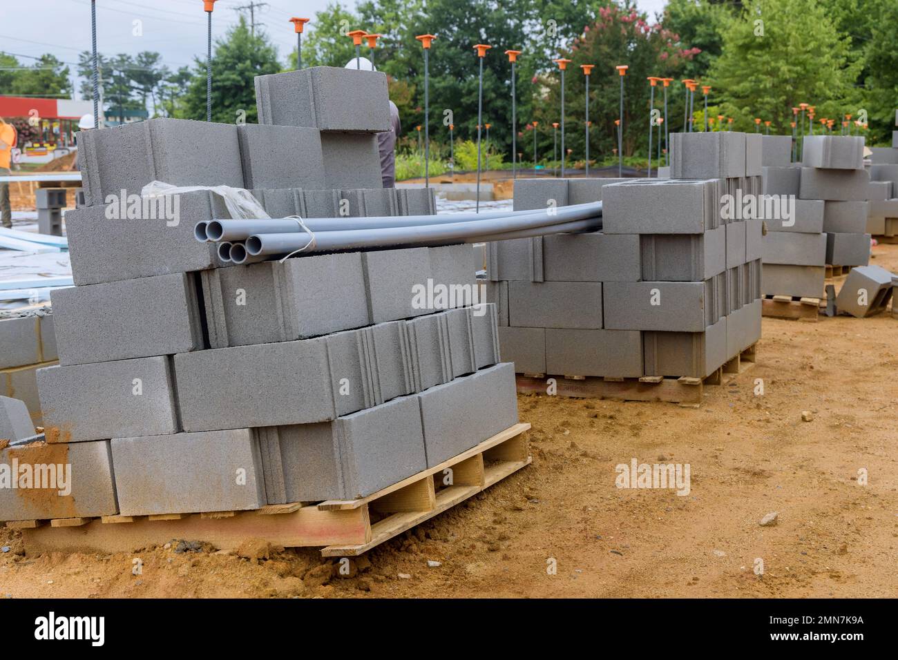 An array of cement blocks ready to be laid on wall of house are stacked side of construction site. Stock Photo