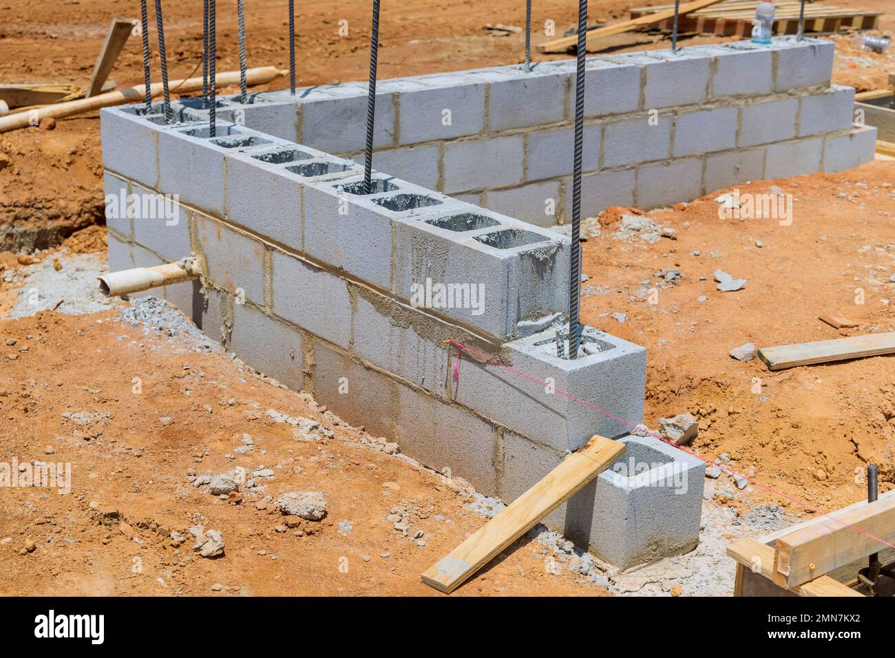 Cement blocks ready to be laid on a wall of a house are stacked on construction site. Stock Photo