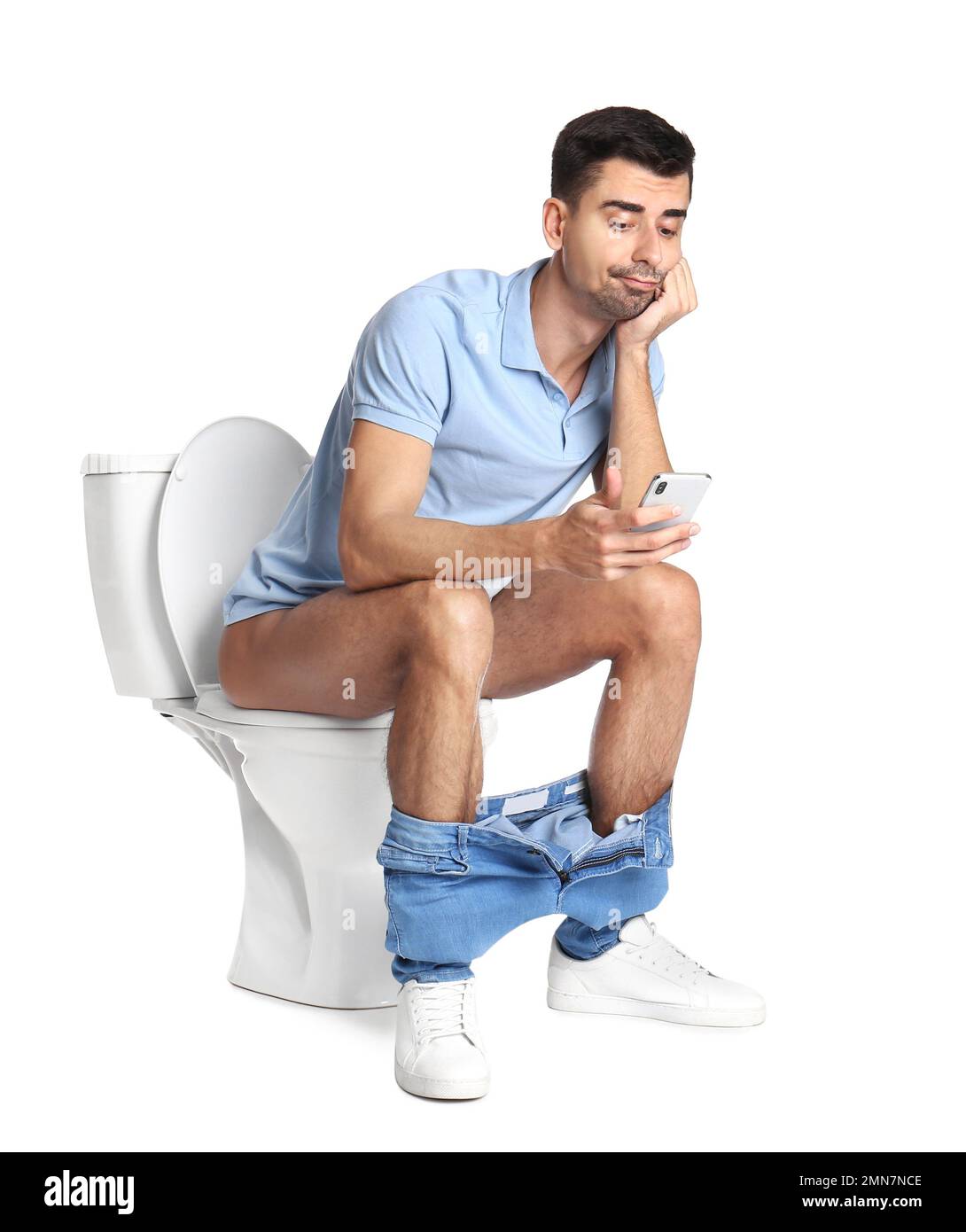 Emotional man with smartphone sitting on toilet bowl, white background ...