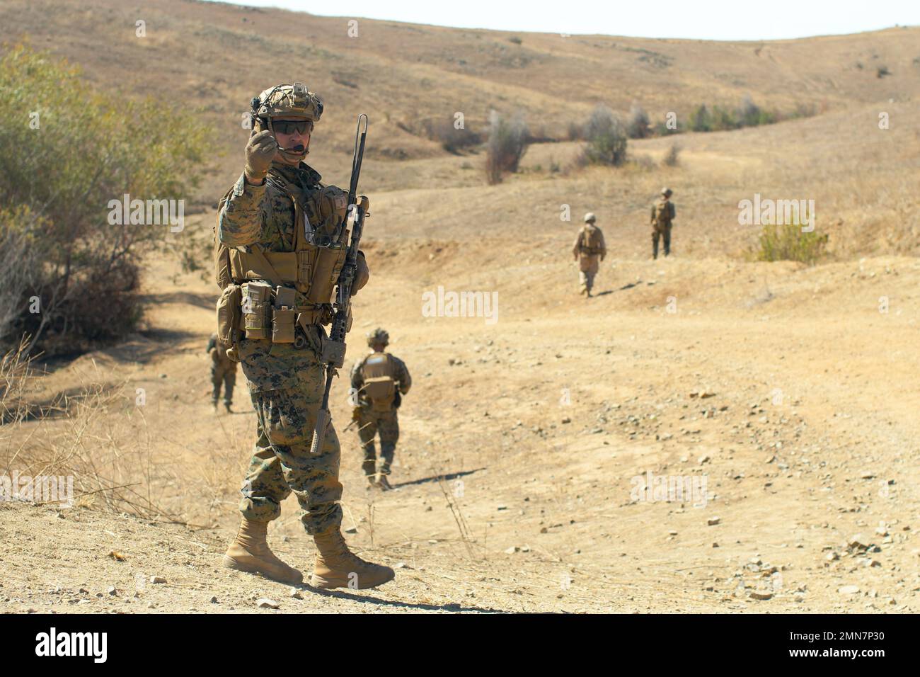 U.S. Marine Corps 2nd Lt. David Higgins, a platoon commander assigned to Charlie Company, 1st Battalion, 1st Marine Regiment, 1st Marine Division directs his squad during a movement to objective as part of a battalion field exercise at Range 800, Marine Corps Base Camp Pendleton, California, September 29, 2022. Range 800 improved Charlie Company’s efficiency in independent platoon operations and basic fire support team skills during the larger FEX, intended to increase the battalion’s combat readiness. Stock Photo