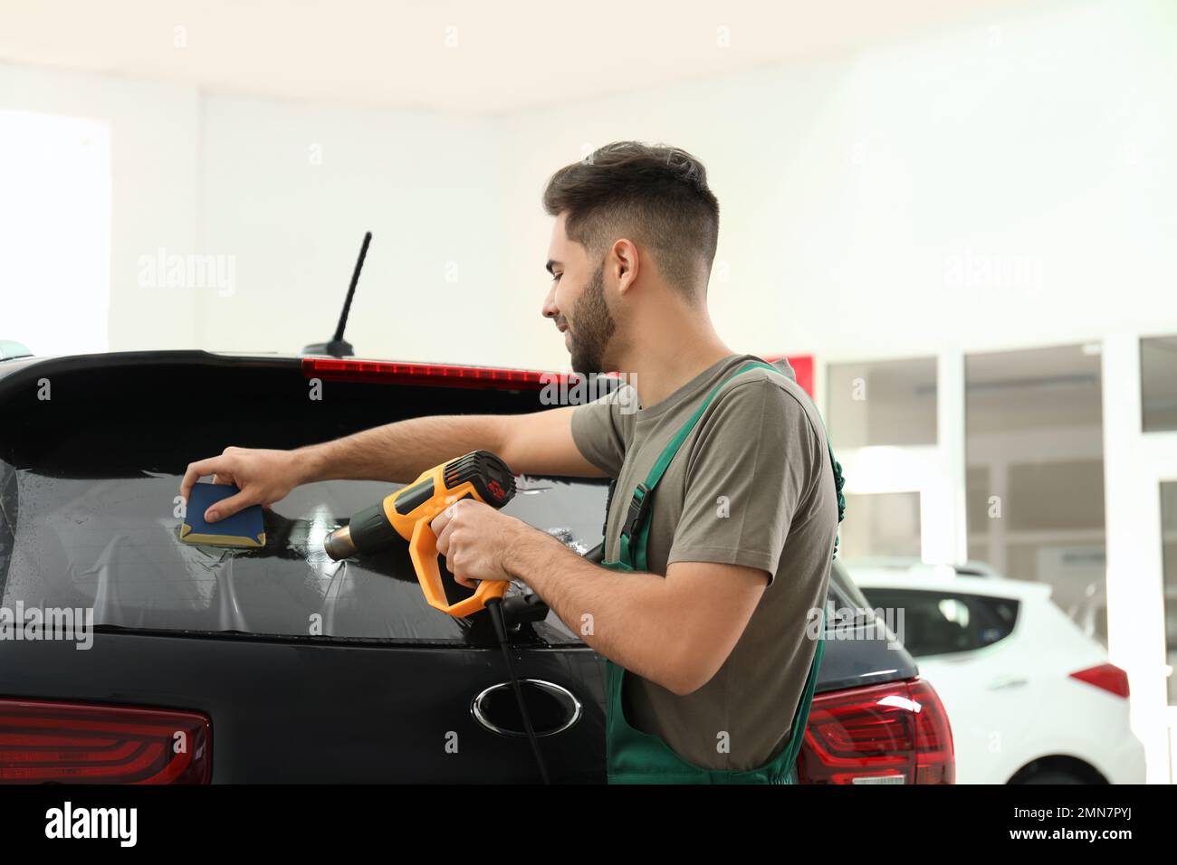 Worker tinting car window with heat gun in Stock Photo Alamy