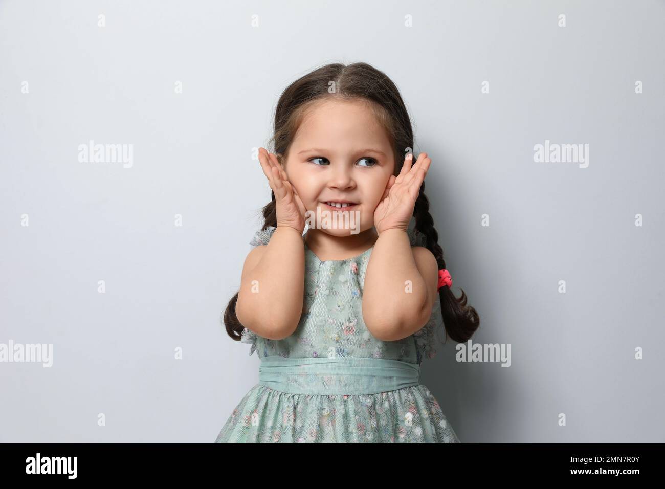 Cute little girl on light grey background Stock Photo Alamy