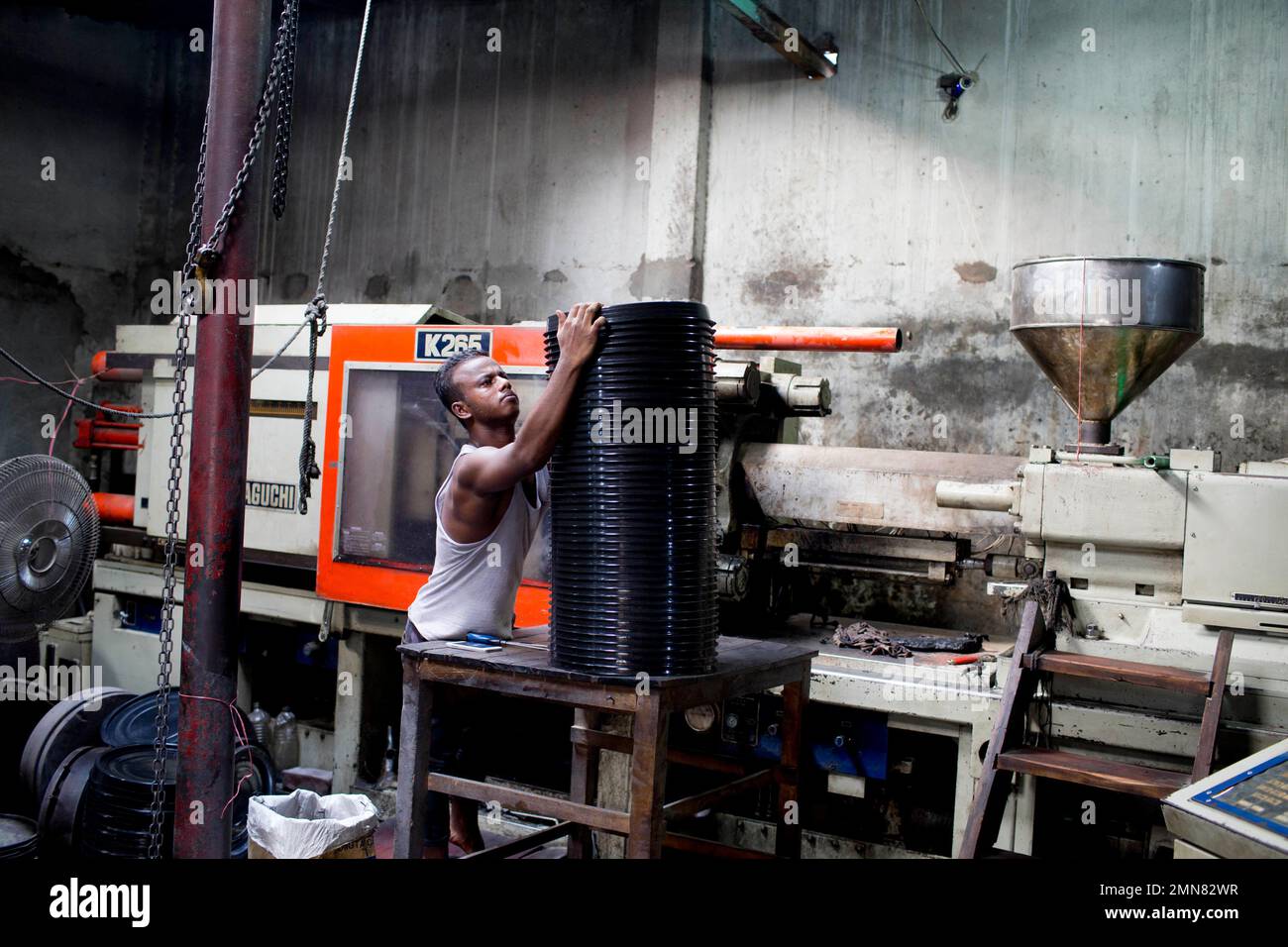 A Bangladeshi worker stacks plastic utensils at a factory in Dhaka, Bangladesh, Monday, June 4