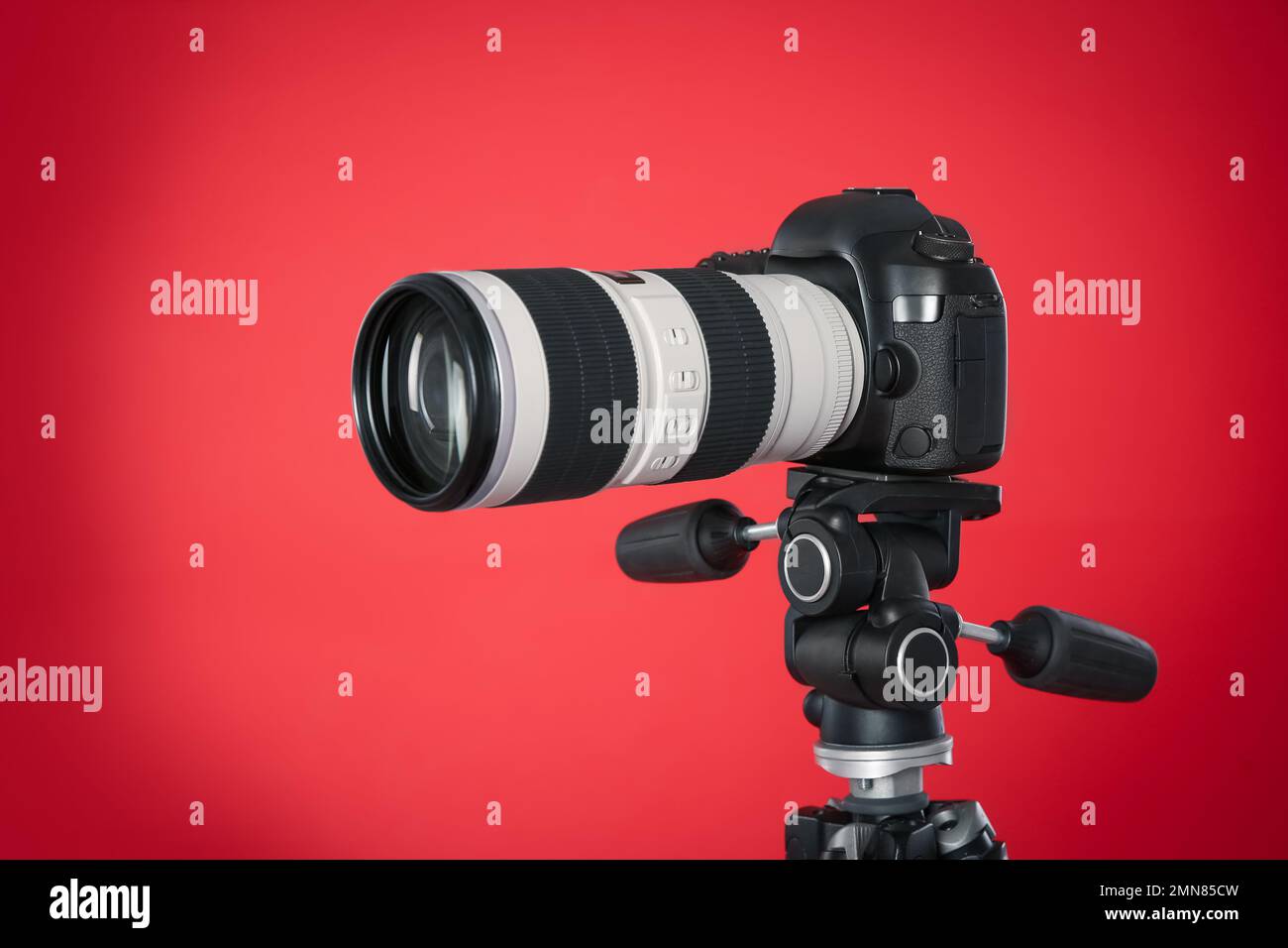 Modern professional video camera on red background Stock Photo