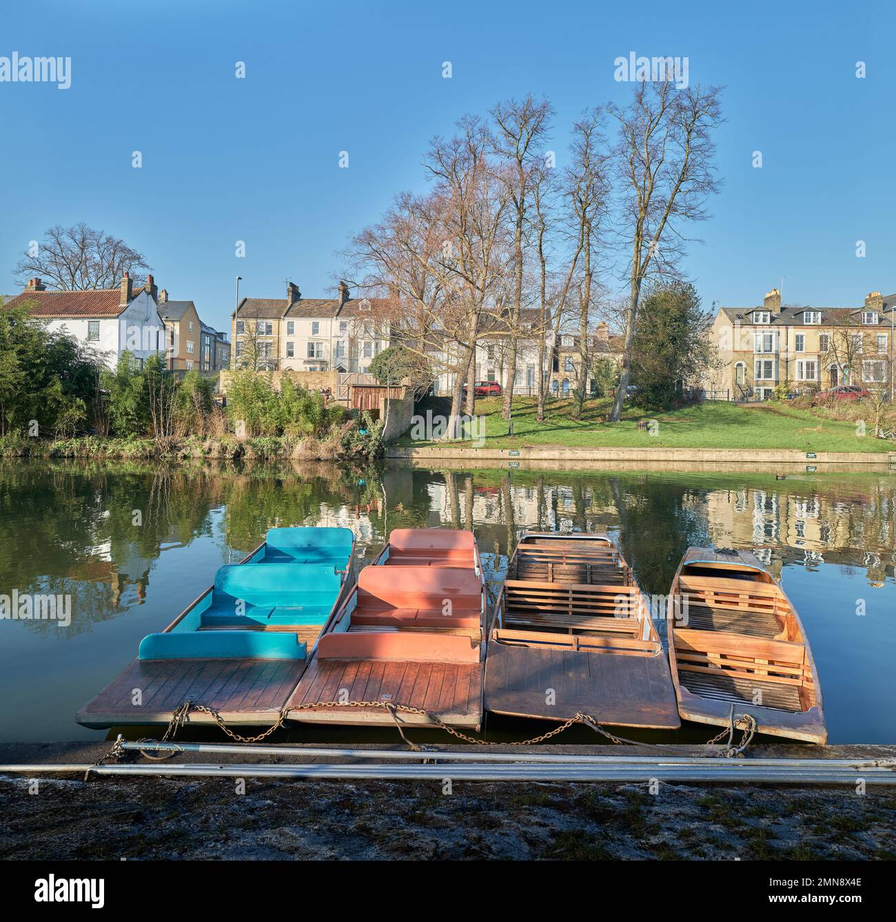 Punts moored to the bank of the river Cam, Cambridge, England, on a sunny winter day. Stock Photo